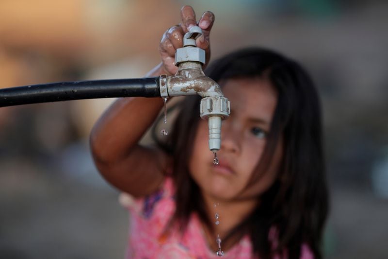 Una niña de la comunidad indígena wichi abre una canilla en Salta, Argentina. Foto de archivo: 28 de febrero, 2020. (REUTERS/Ueslei Marcelino)