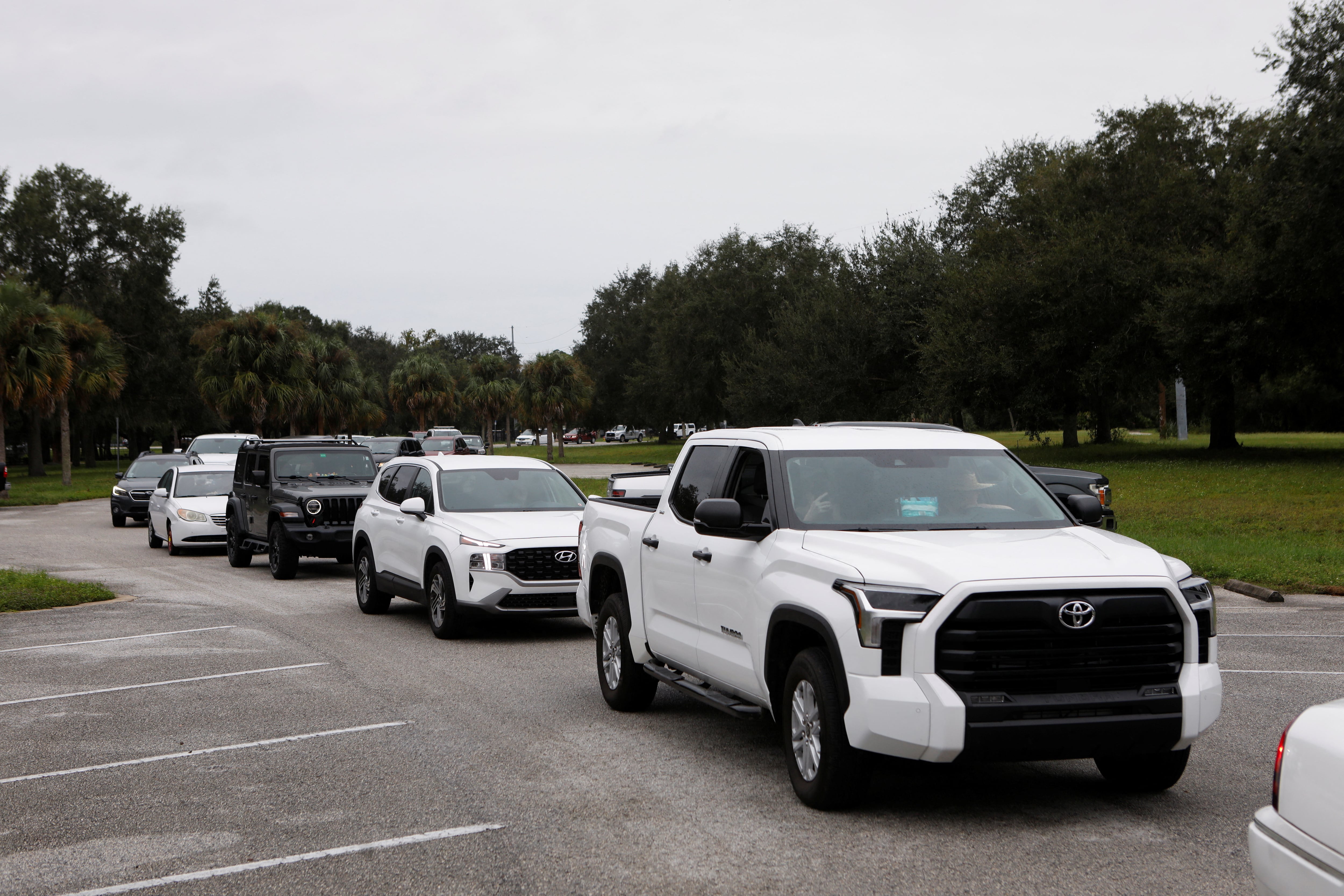 La gente se sienta en sus autos mientras se distribuyen bolsas de arena a los residentes del condado de Pinellas antes de la llegada prevista de la tormenta tropical Milton, en Seminole, Florida, EE. UU., el 6 de octubre de 2024. REUTERS/Octavio Jones