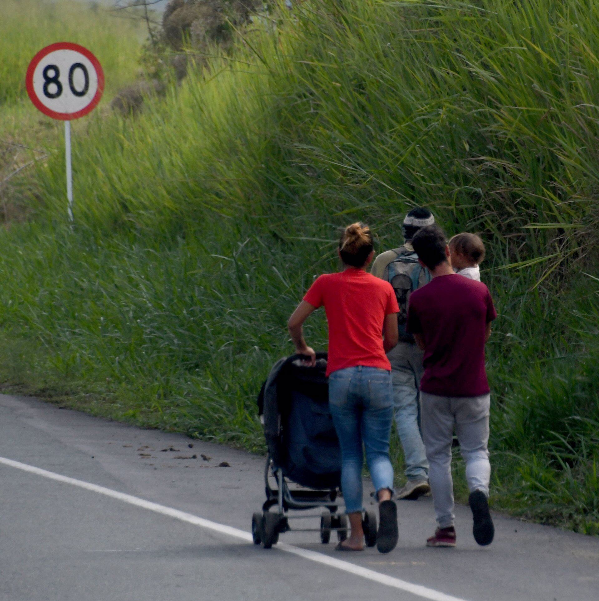 Una familia venezolana camina por una carretera colombiana rumbo al Tapón del Darien.