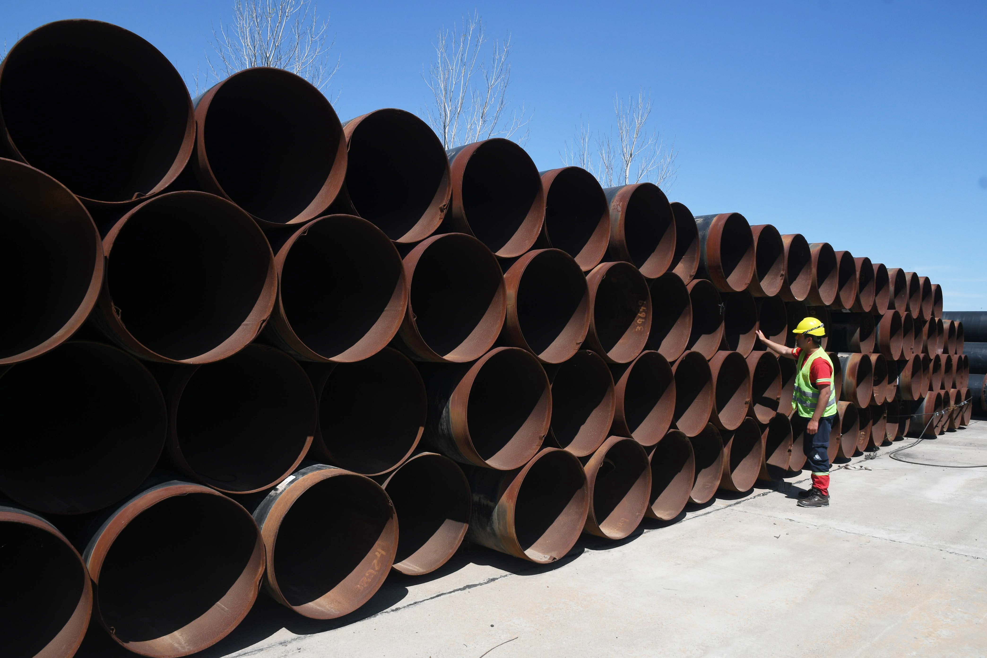 Un trabajador inspecciona tuberías antes de ser transportadas para construir el gasoducto que conectará las localidades de Tratayén y Salliqueló (DPA)
