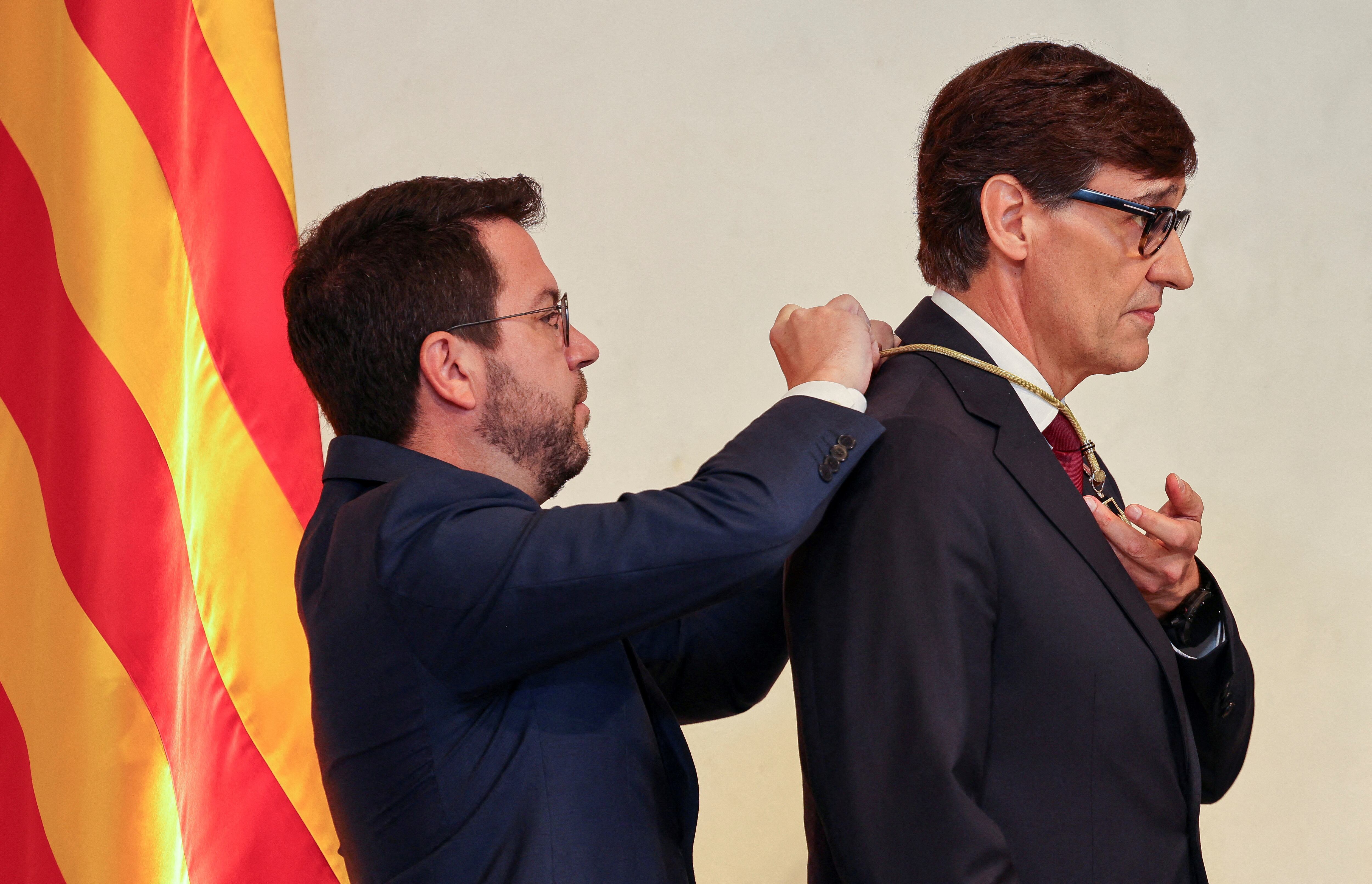 Salvador Illa recibe una medalla de las manos de Pere Aragonès al tomar posesión de su cargo como President de la Generalitat. (REUTERS/Nacho Doce)