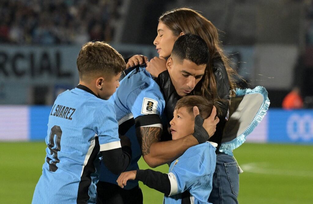 Luis Suárez junto a su familia en el campo de juego del Centenario (EITAN ABRAMOVICH / AFP)