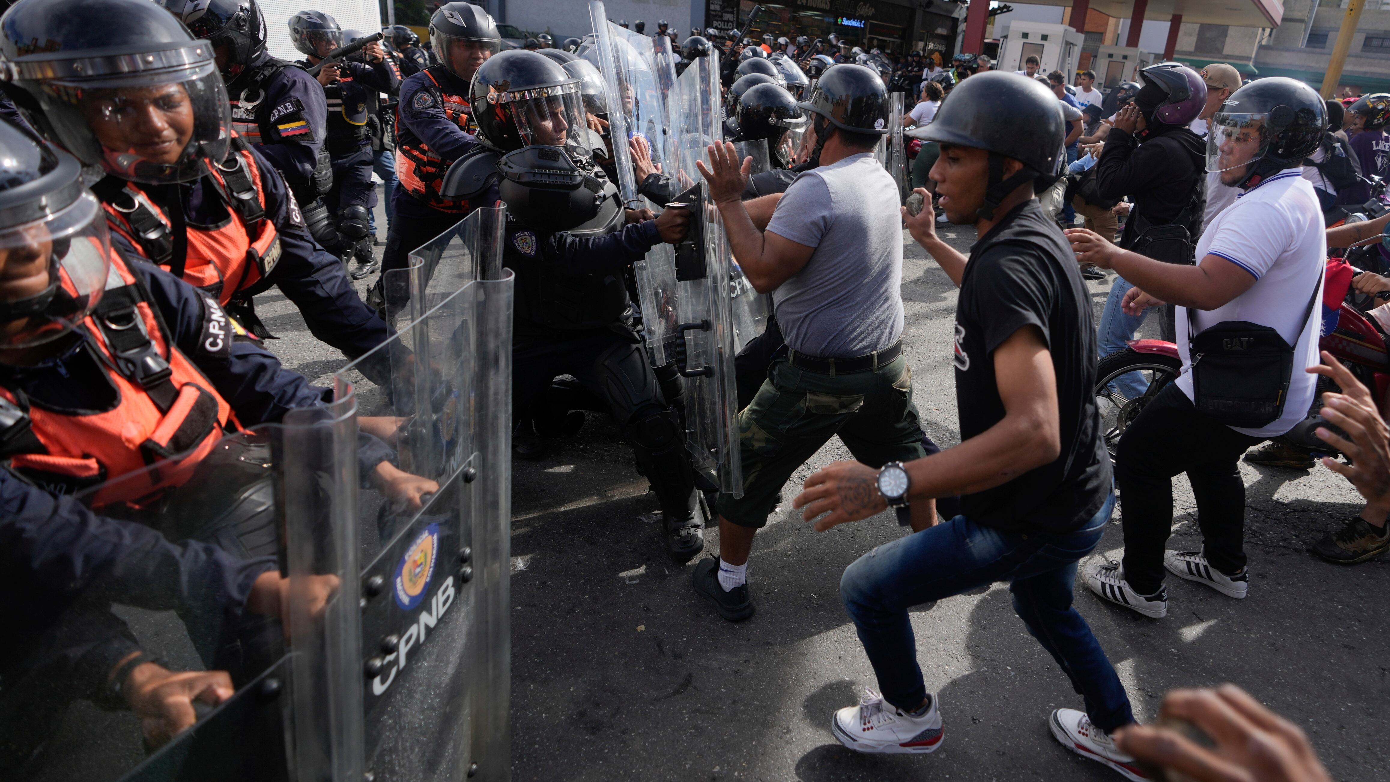 Los manifestantes cargan contra la policía durante manifestaciones contra los resultados oficiales de las elecciones (AP Foto/Fernando Vergara)