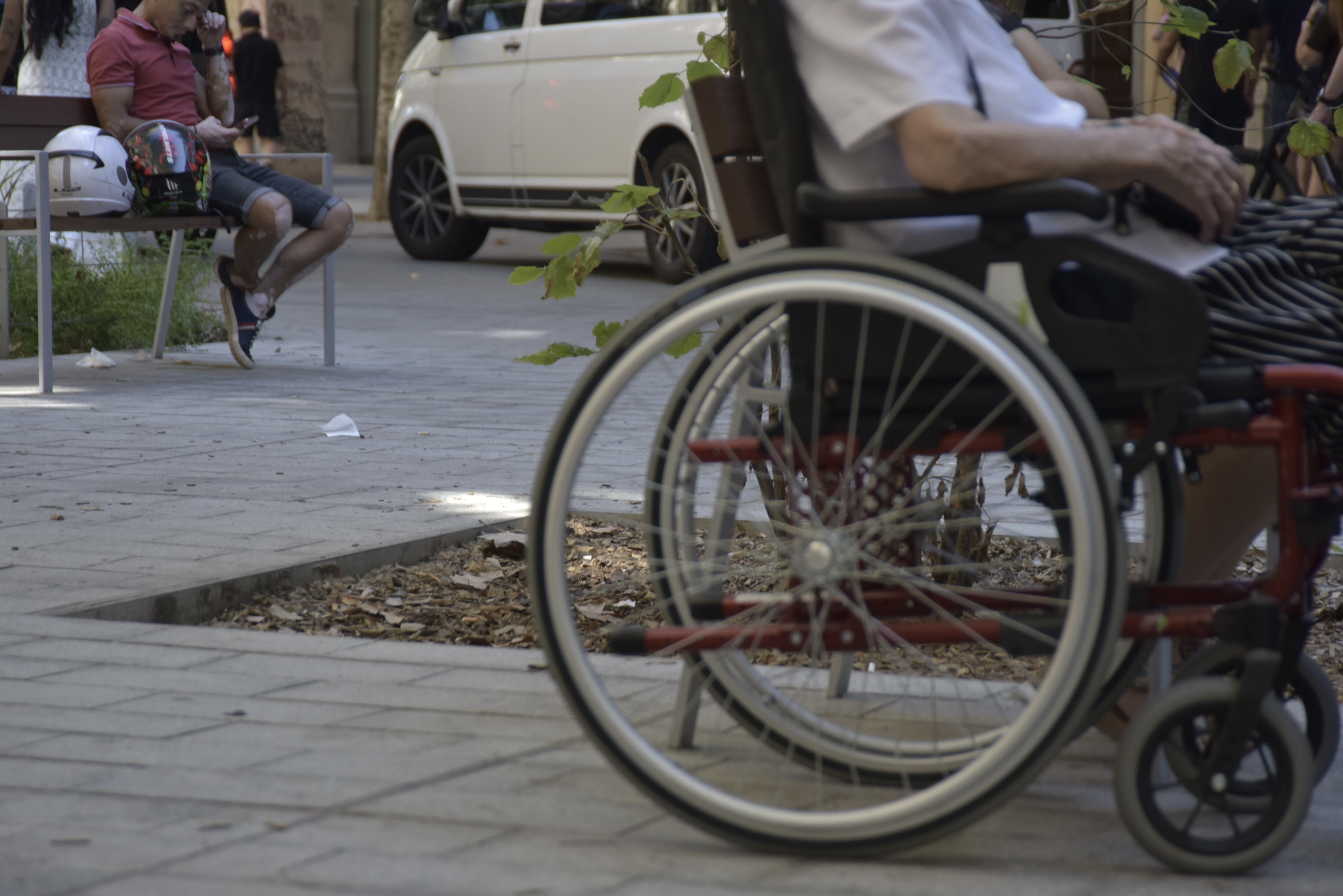 Una persona en silla de ruedas en la calle Consell de Cent, en Barcelona. (David Oller / Europa Press)
