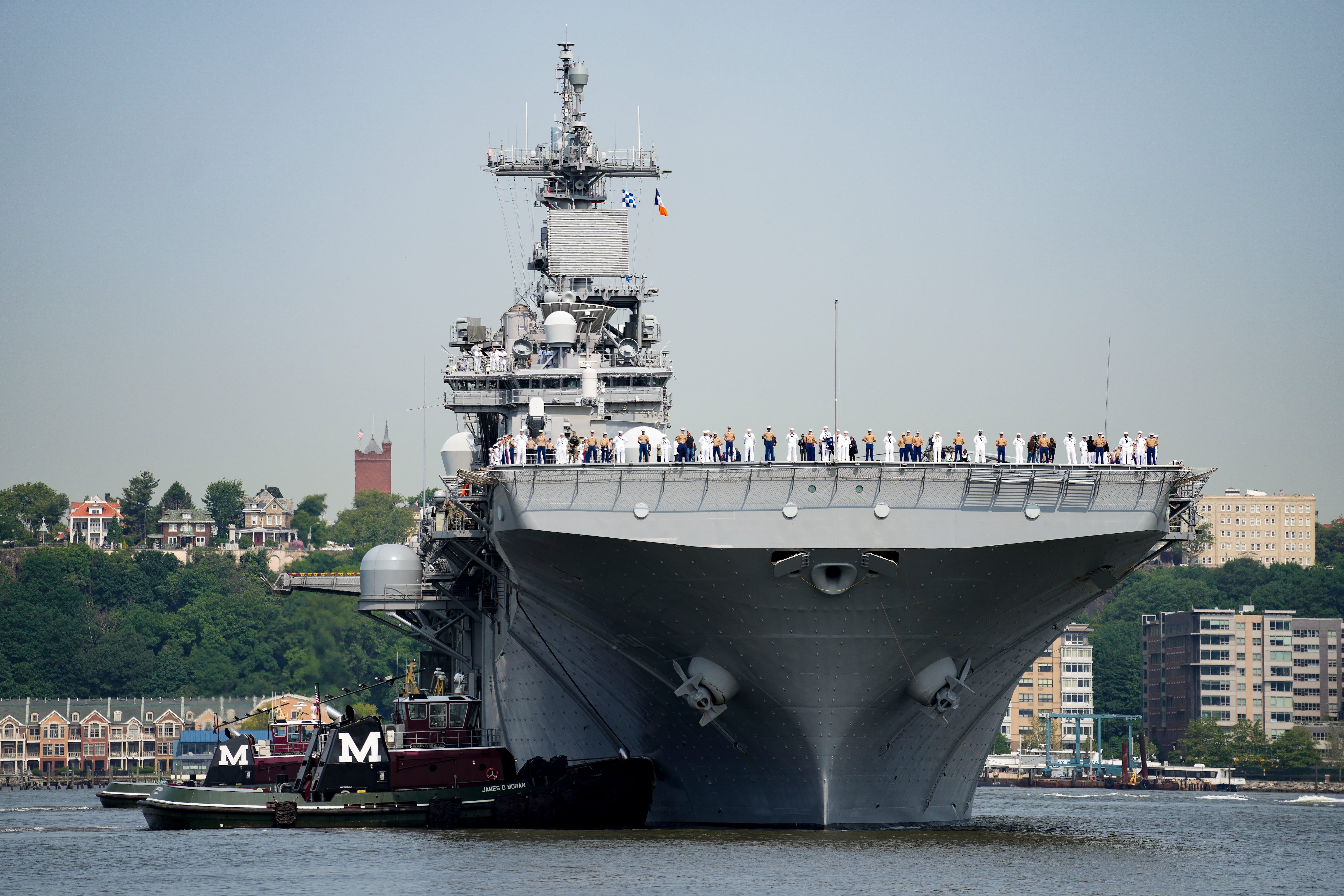 Marinos y personal del servicio militar llegan al USS Wasp en el río Hudson, en Nueva York (AP Foto/John Minchillo)