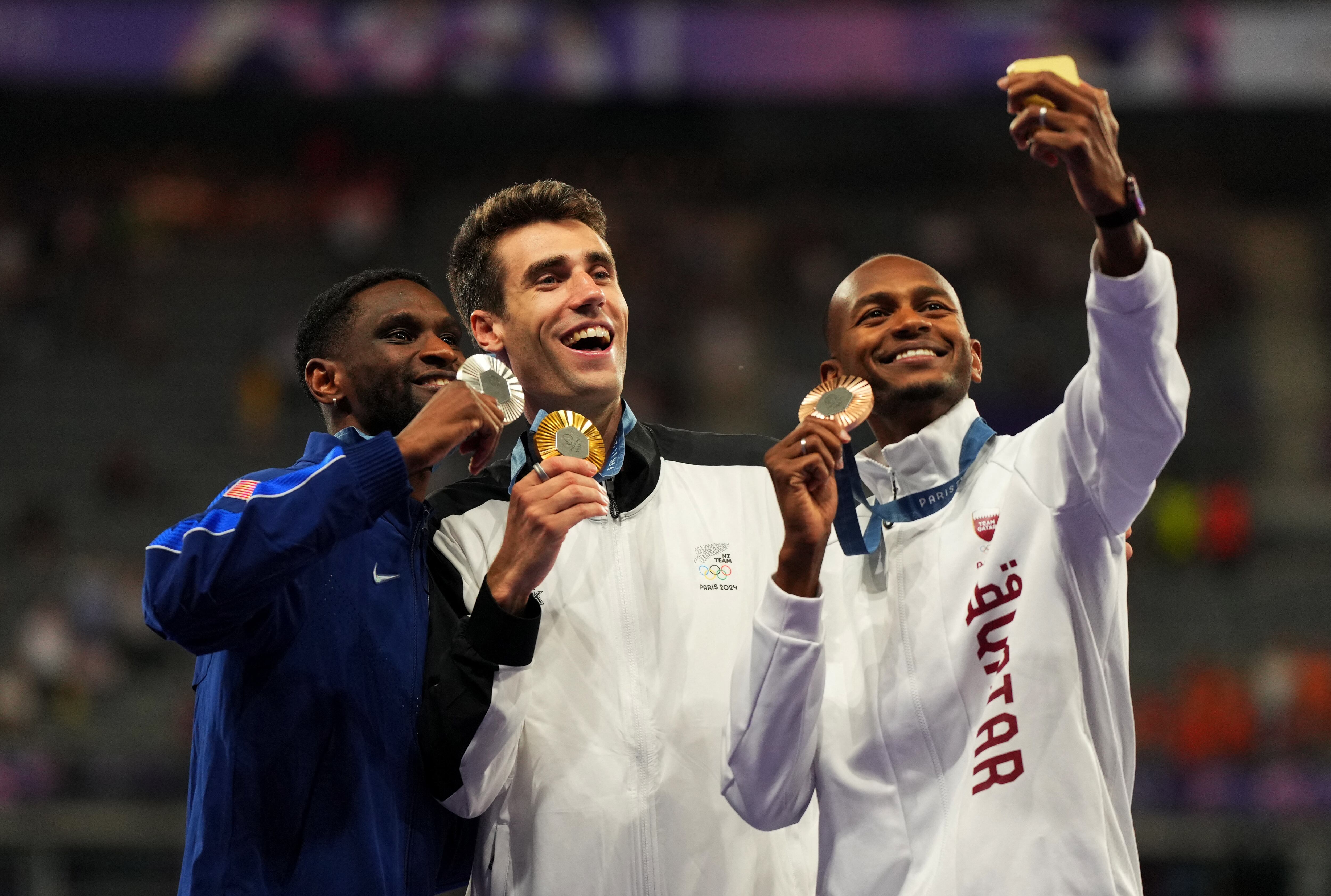 Hamish Kerr celebró en el podio junto a Shelby McEwen (Plata) y Mutaz Essa Barshim (bronce)