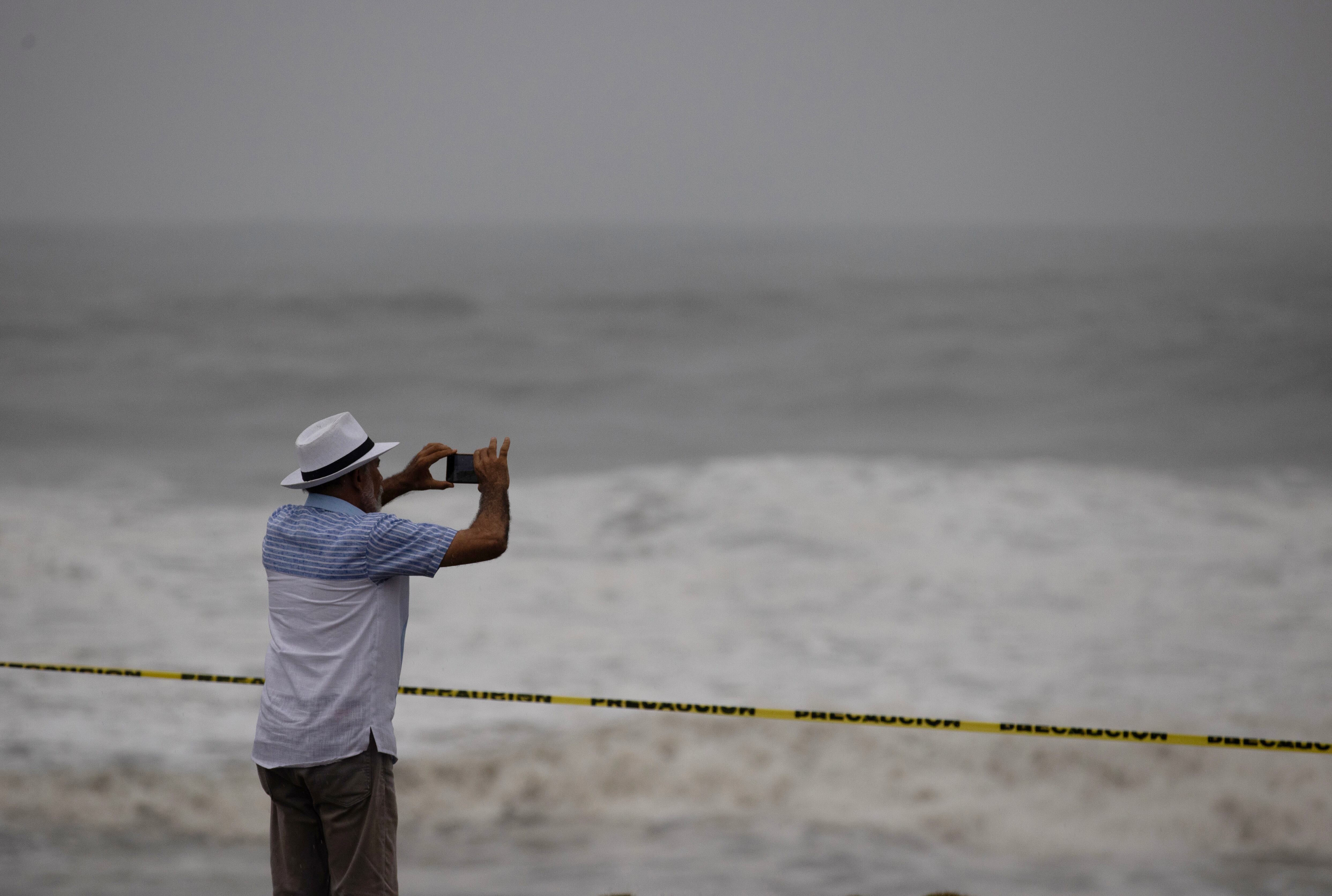 Un hombre observa el fuerte oleaje durante el paso del huracán Beryl, este martes en el malecón de Santo Domingo (República Dominicana). EFE/ Orlando Barría 