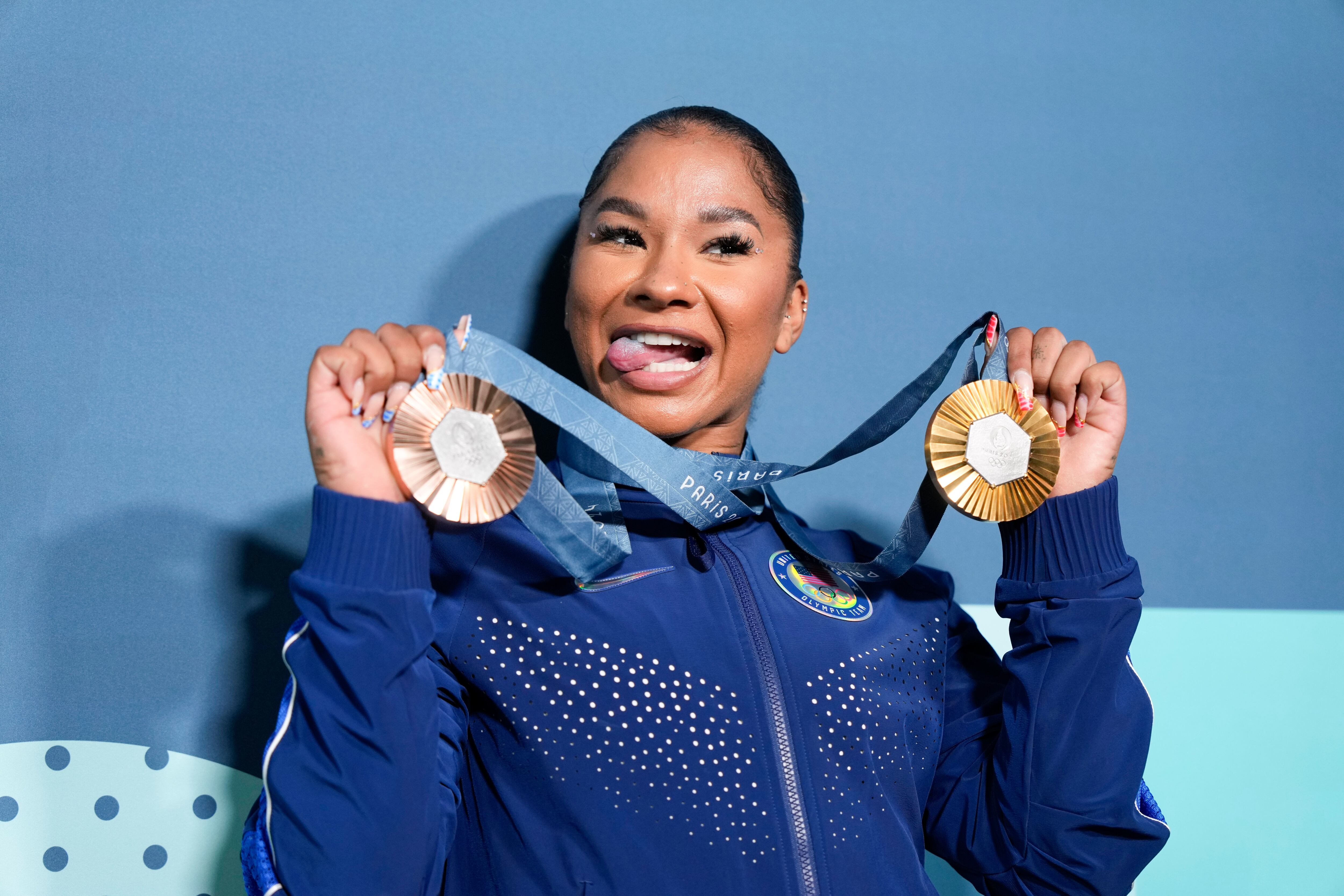 Jordan Chiles sostiene sus medallas, la dorada y la de bronce, la cual tuvo que devolver (AP Foto/Charlie Riedel)