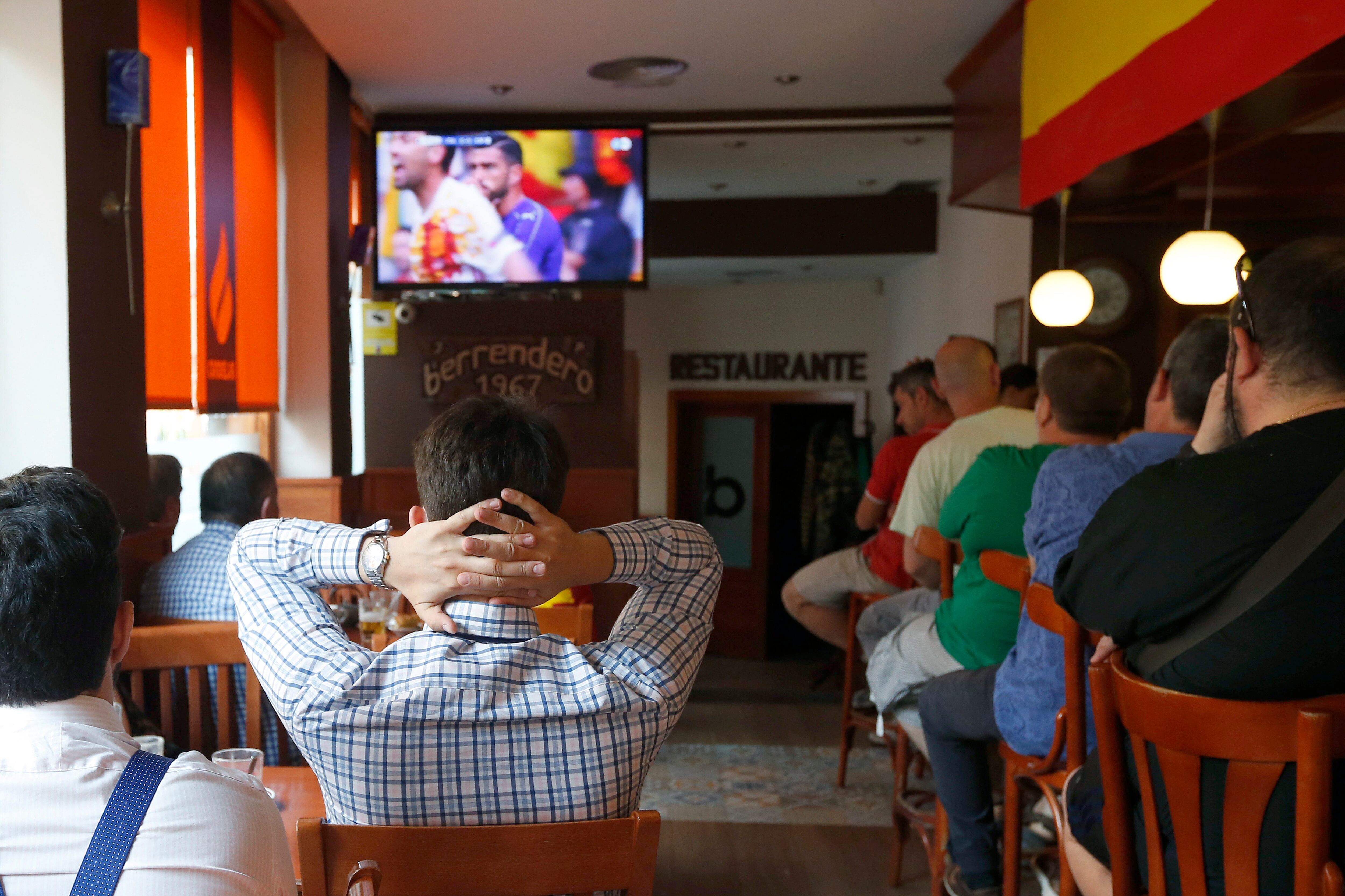 Varios aficionados siguen en un bar de Madrid un partido de fútbol. (Chema Moya/EFE)