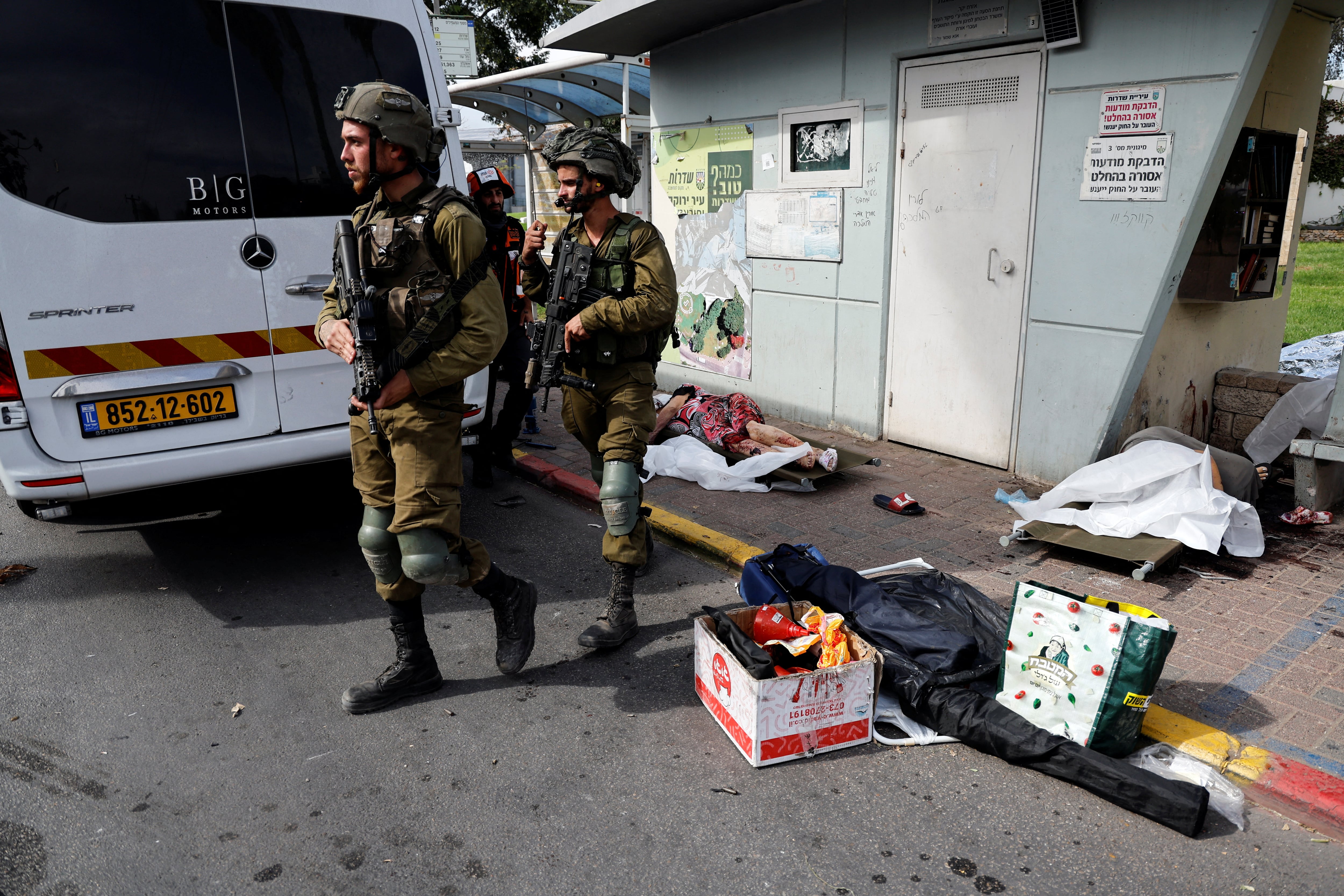 Soldados israelíes caminan junto a los cadáveres de personas en una calle de Sderot
