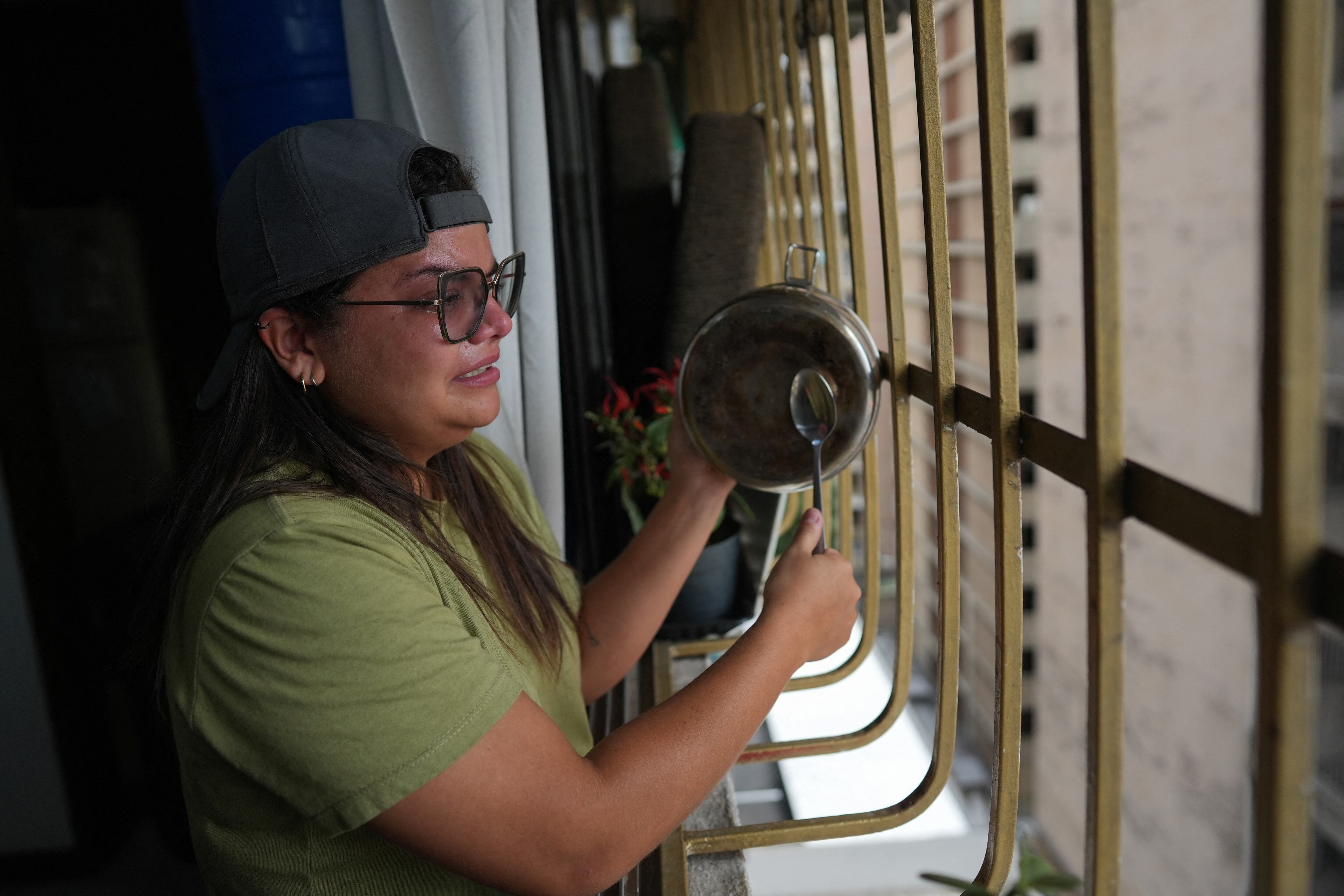 La ingeniera Nejcareth Paz golpea una olla desde su apartamento en protesta por los resultados electorales en Caracas (REUTERS/Alexandre Meneghini)
