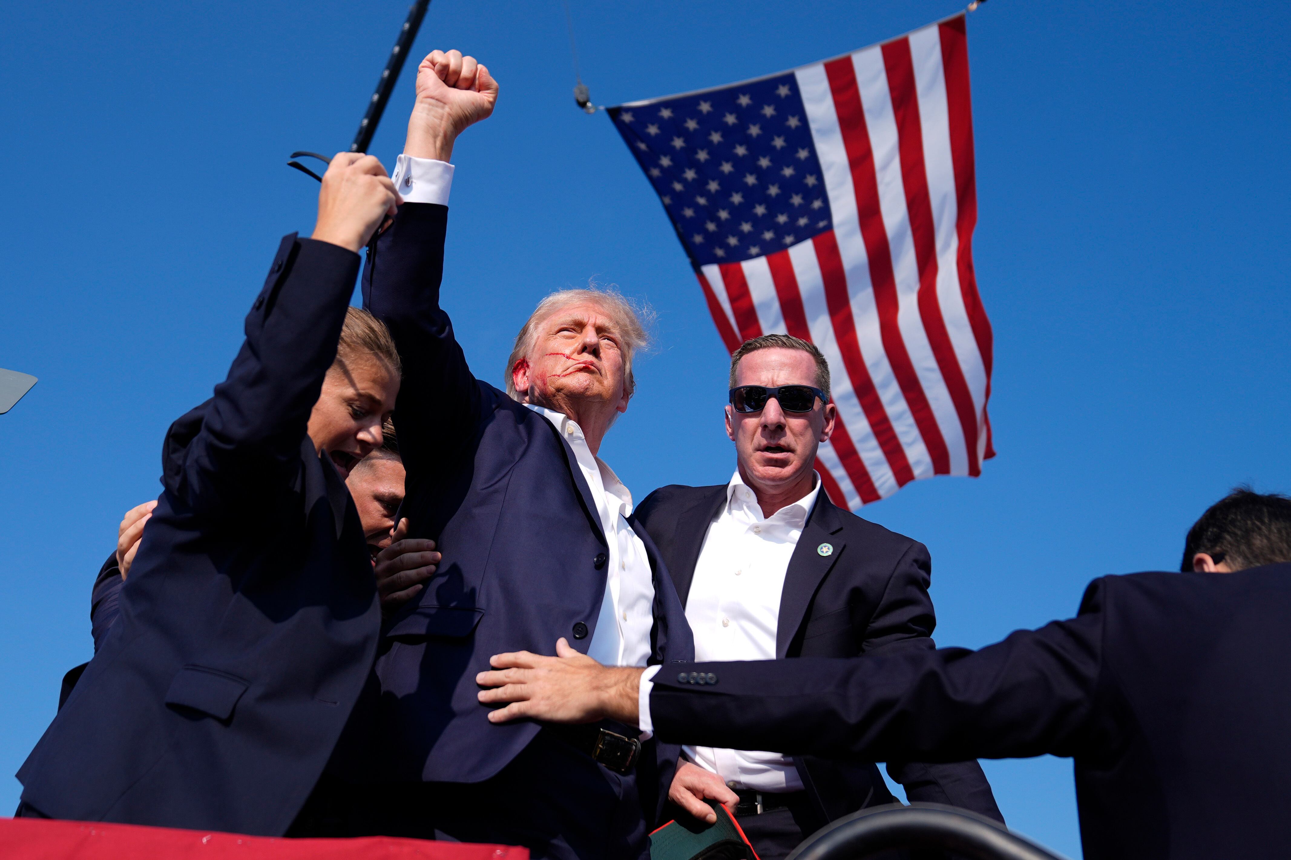 El candidato republicano Donald Trump es rodeado por agentes del Servicio Secreto en un acto de campaña el sábado 13 de julio de 2024 en Butler, Pensilvania, tras un intento de asesinato (AP Foto/Evan Vucci)