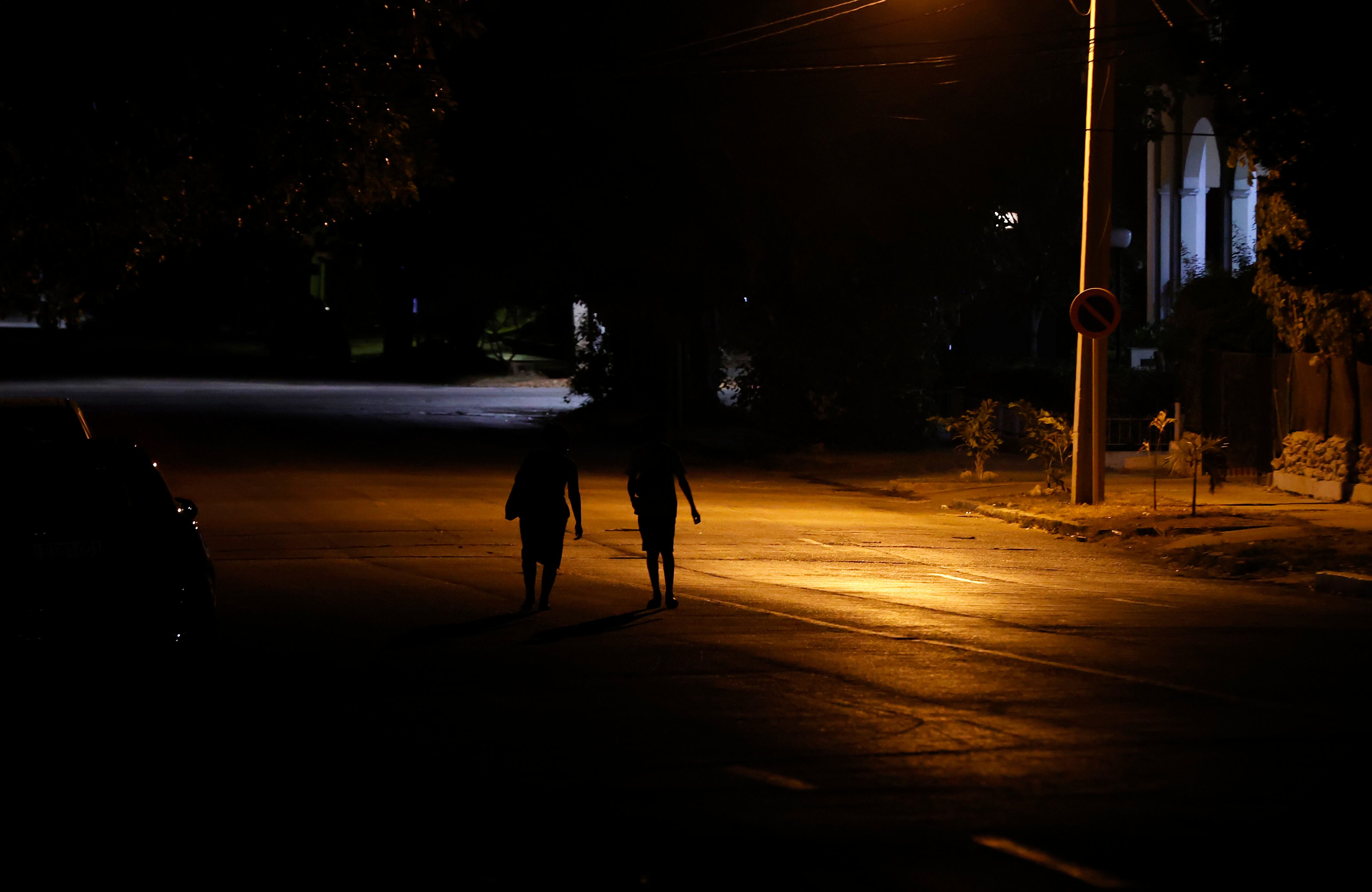 Personas que caminan por una calle con poca iluminación en La Habana (EFE/Ernesto Mastrascusa)
