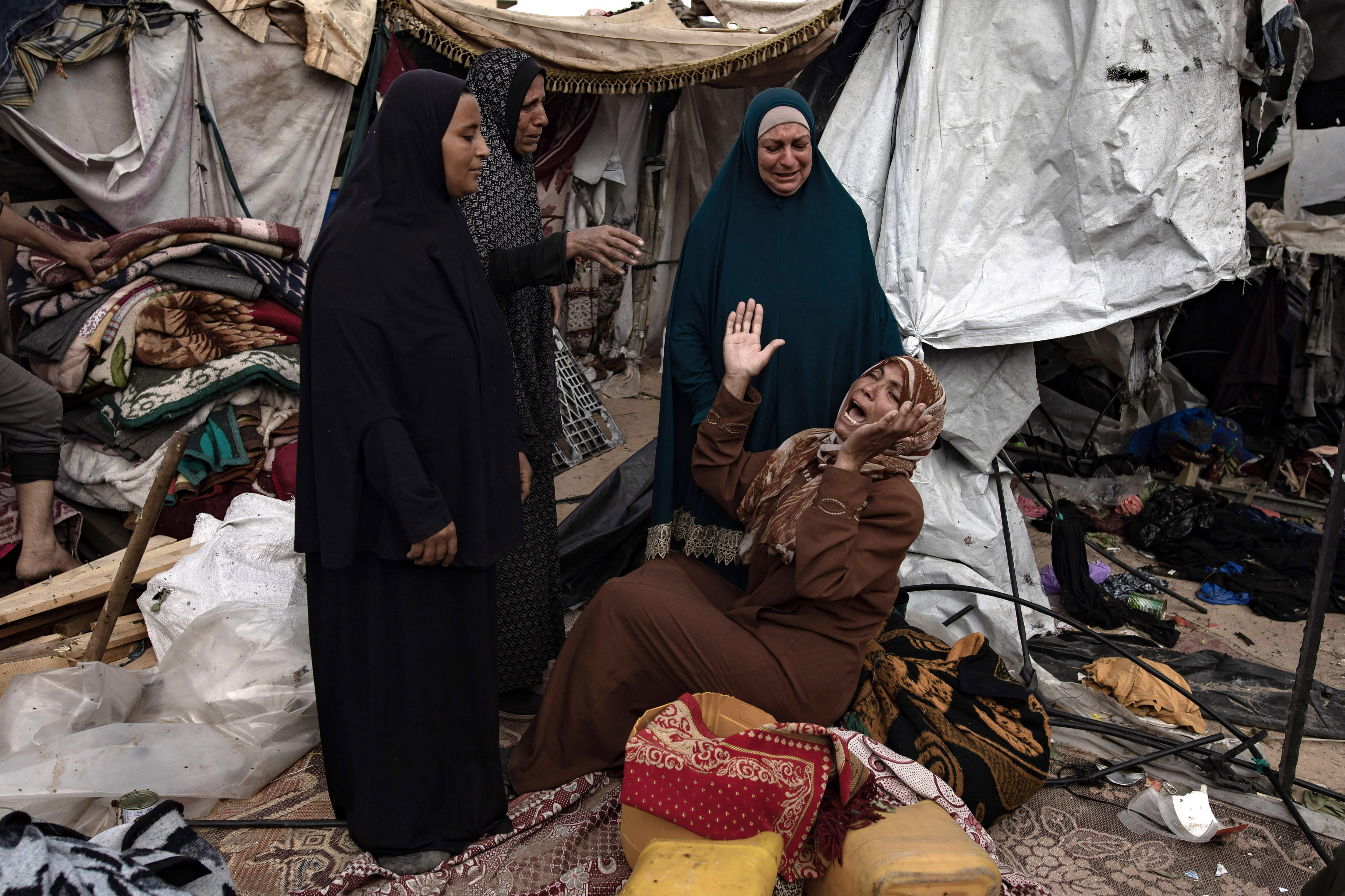 Fotografía en donde aparece una mujer mientras los palestinos inspeccionan sus tiendas de campaña después de una operación del ejército israelí. EFE/Haitham Imad
