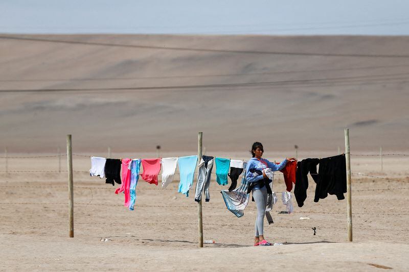 FOTO DE ARCHIVO-Una migrante indocumentada cuelga ropa en un tendedero improvisado, en la zona de Chacalluta, Arica, Chile. 6 de mayo de 2023. REUTERS/Hugo Curotto