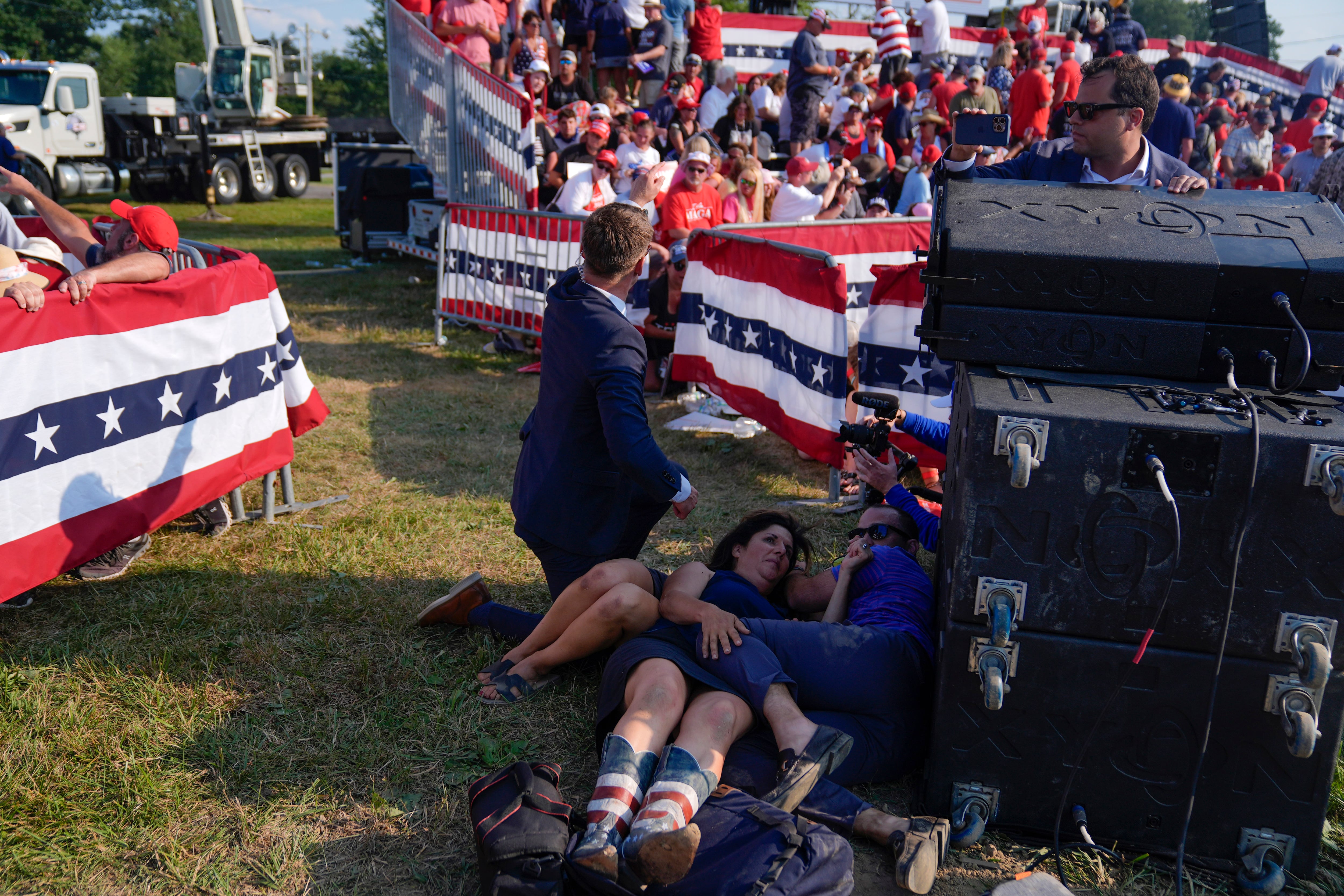 Personas se cubren durante el tiroteo en el mitin de campaña del ex presidente Trump el sábado en Butler, Pennsylvania. (AP Foto/Evan Vucci)