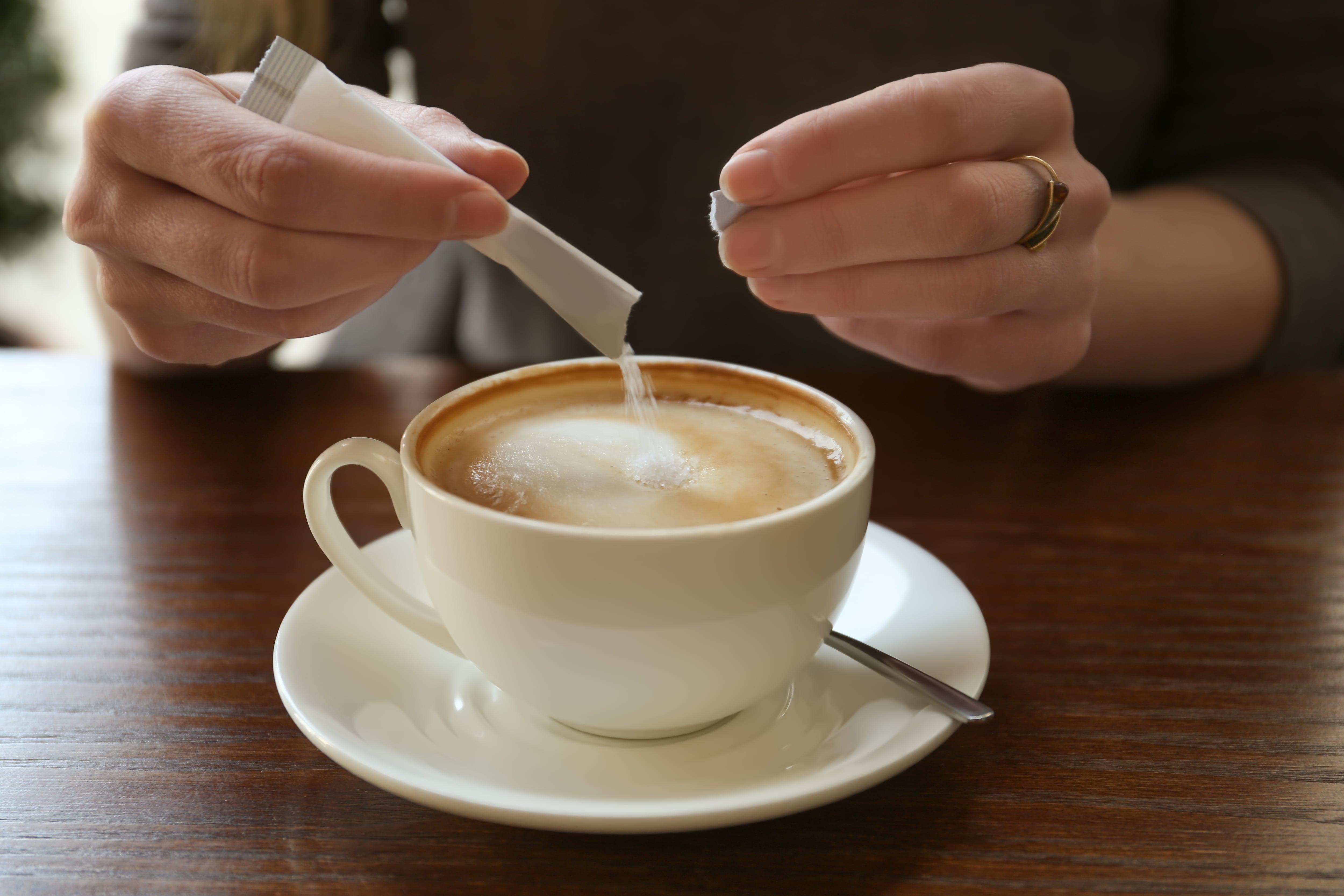 Una joven añade azúcar a su café (Shutterstock)