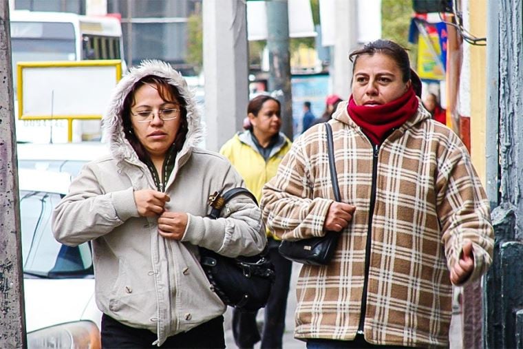 Dos mujeres caminan en día de invierno bien abrigadas ante las bajas temperaturas registradas en la capital peruana.