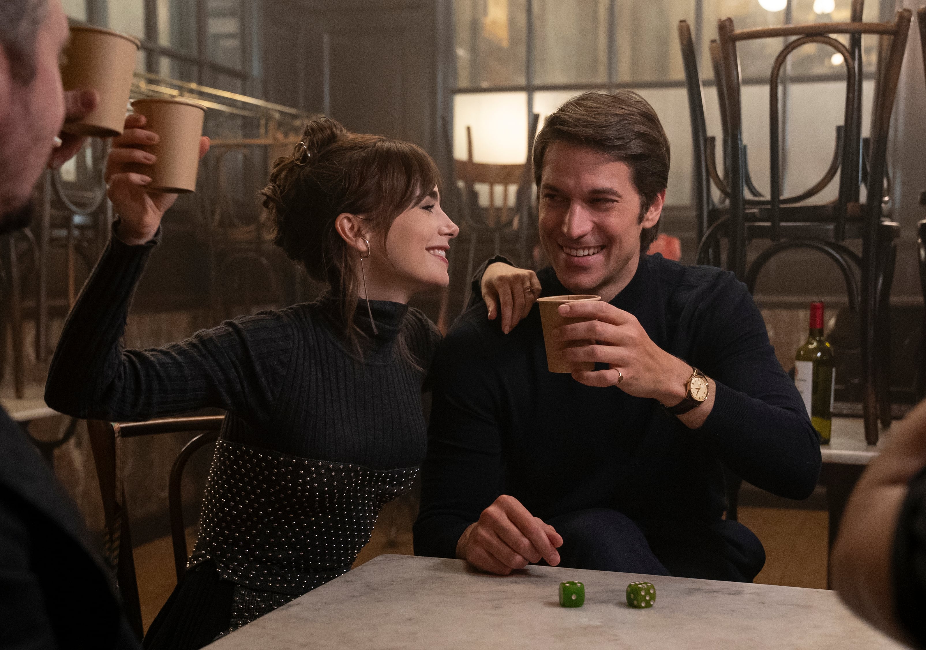 En esta imagen proporcionada por Netflix, Lily Collins, izquierda, y Lucas Bravo en una escena de 'Emily in Paris' (Stephanie Branchu/Netflix vía AP)