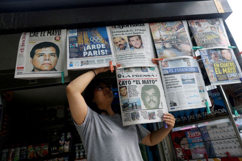 FOTO DE ARCHIVO: Una vendedora de periódicos ordena los diarios que informan sobre la detención en El Paso, Texas, Estados Unidos, del narcotraficante mexicano Ismael "El Mayo" Zambada y Joaquín Guzmán López, hijo de "El Chapo" Guzmán, en Ciudad de México, México. 26 de julio de 2024. REUTERS/Gustavo Graf/Archivo