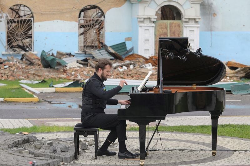 FOTO DE ARCHIVO. El músico lituano Darius Mazintas toca un piano frente a la Casa Central de Cultura destruida durante la invasión rusa, en la ciudad de Irpin, en las afueras de Kiev, Ucrania, el 26 de abril de 2022. REUTERS/Mykola Tymchenko