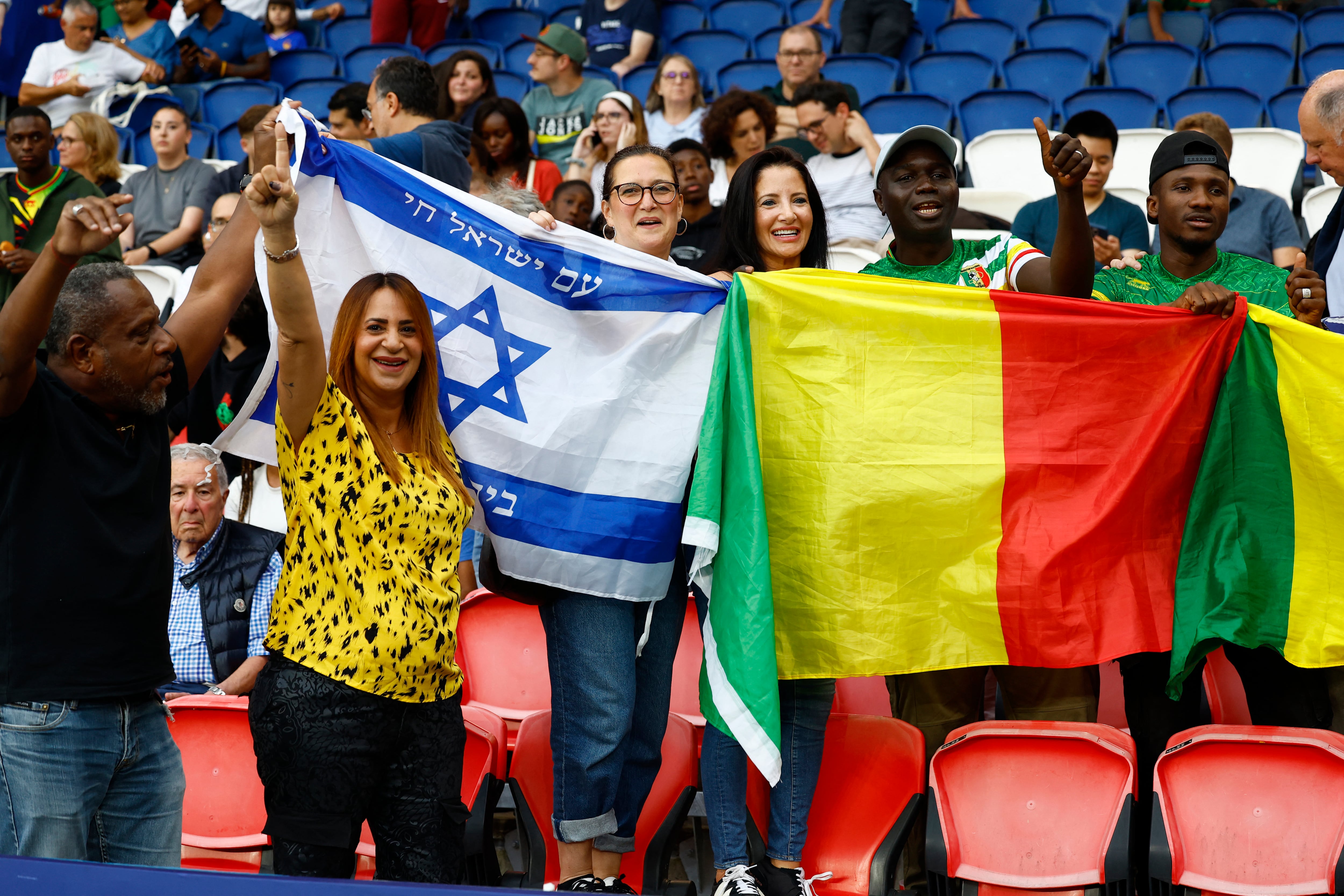 Simpatizantes de Malí e Israel disfrutan juntos el partido de sus seleccionados de fútbol en el Parque de los Príncipes de París. El encuentro terminó empatado 1-1 en el inicio de los Juegos Olímpicos (REUTERS/Piroschka Van De Wouw)