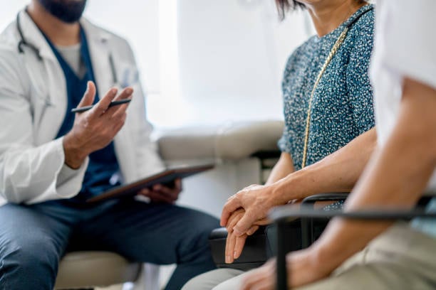 Un doctor le explica a un paciente y su familiar cómo funciona la terapia de los cuidados paliativos para las personas que sufren una enfermedad terminal