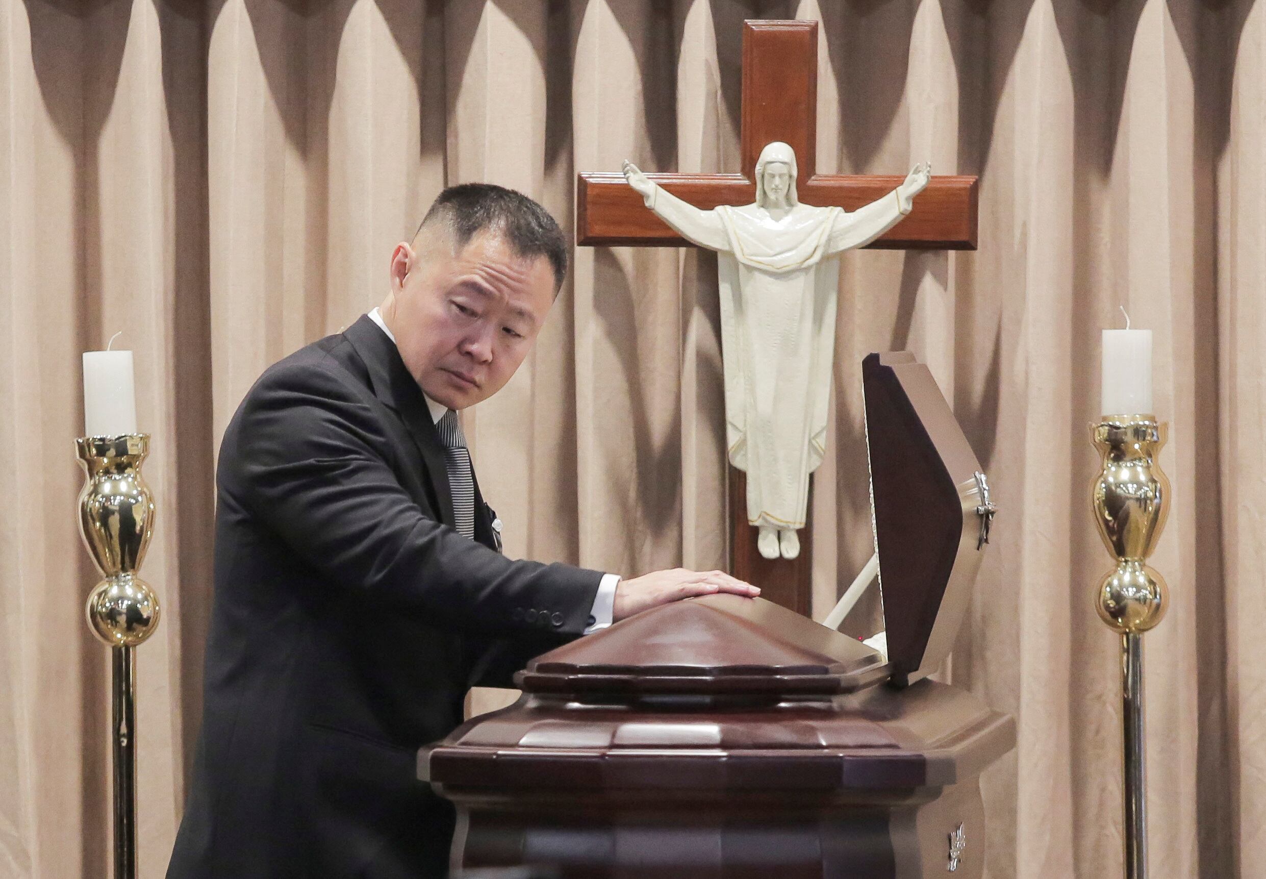 Kenji Fujimori pays his respects at the coffin containing the body of his father, Peru's former President Alberto Fujimori, as it is exhibited for a posthumous tribute, at the Museo de la Nacion, in Lima, Peru, September 12, 2024. REUTERS/Gerardo Marin