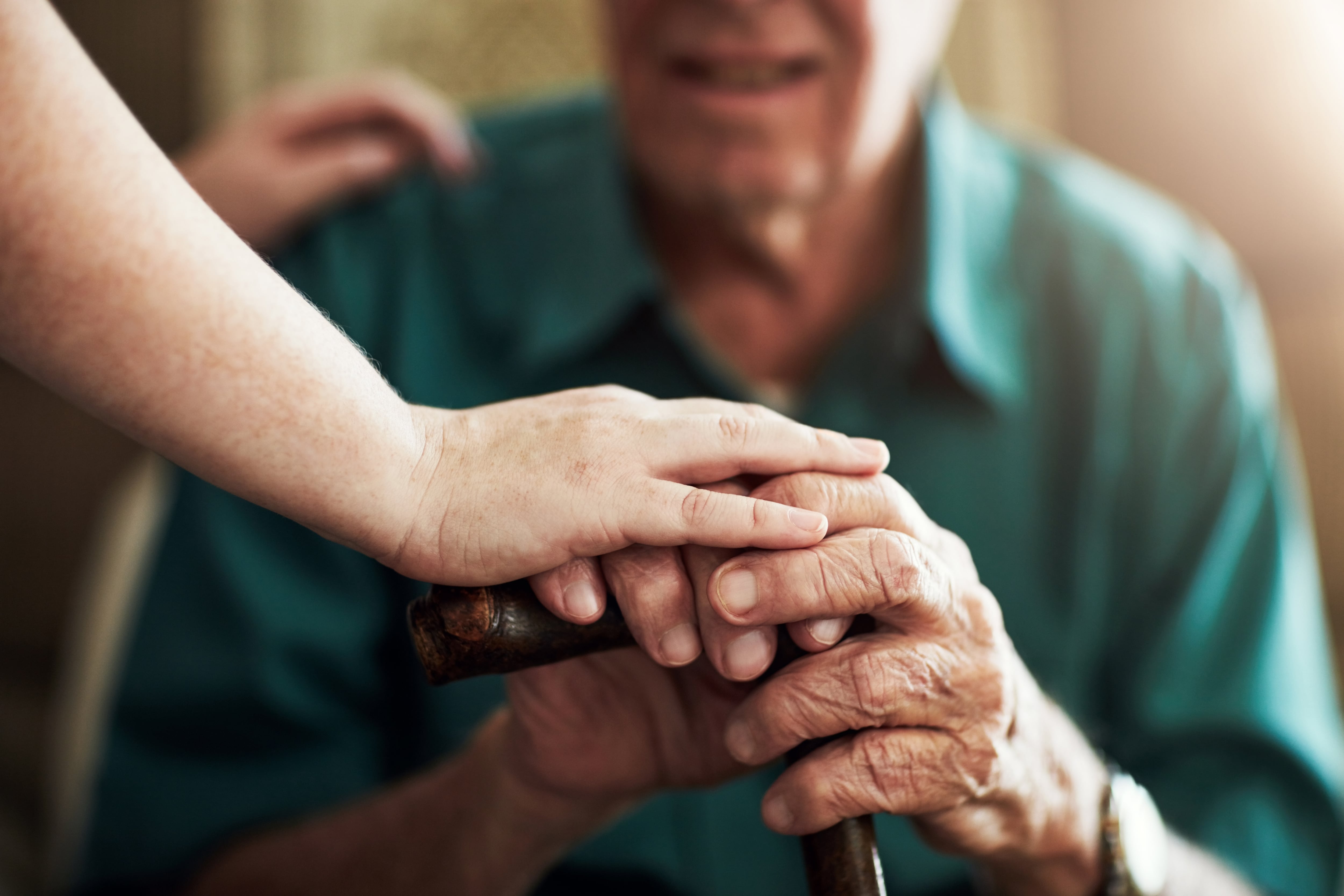 Manos de un anciano sosteniendo un bastón (Shutterstock España)