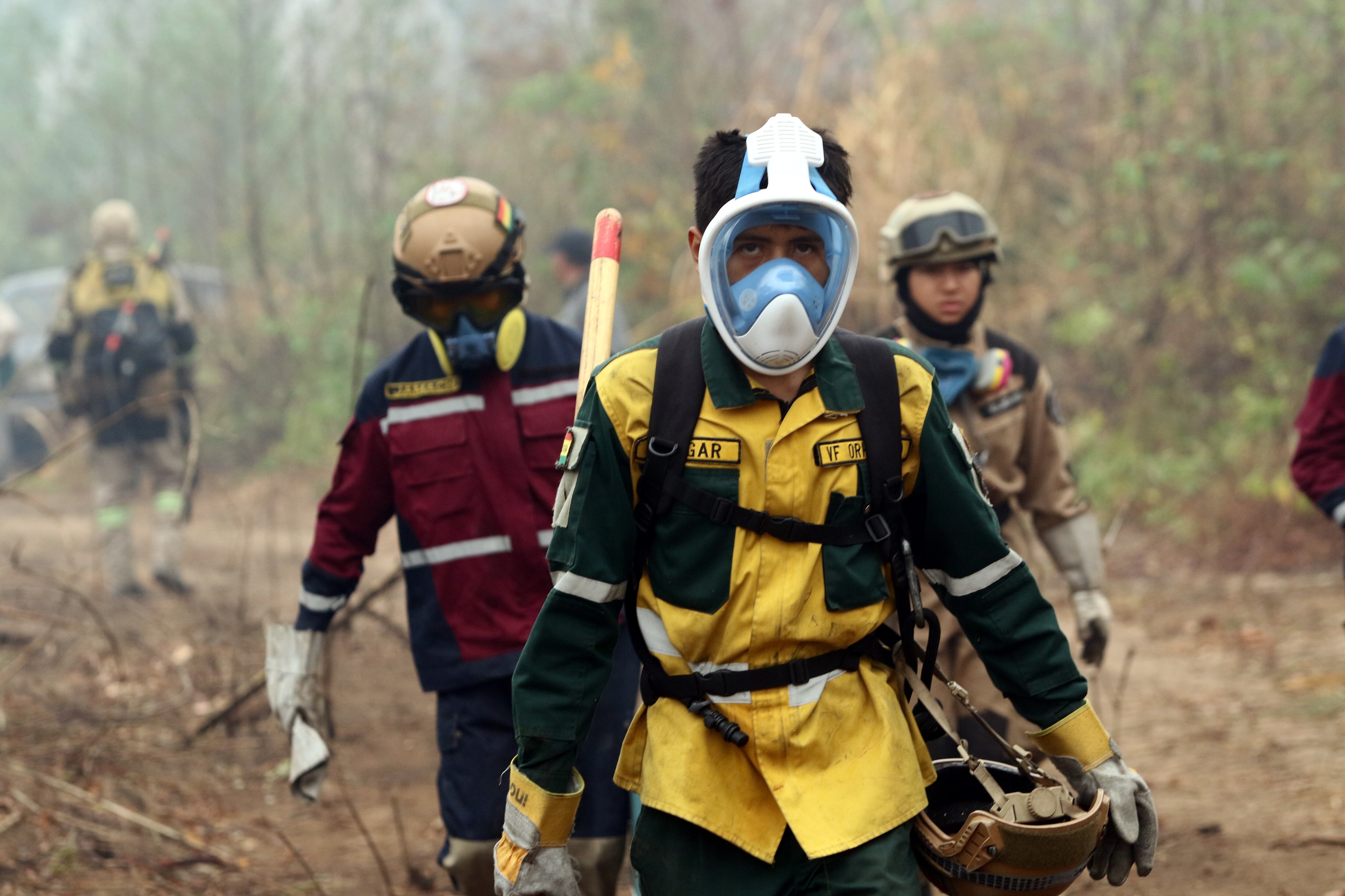 Bomberos y pobladores trabajan para enfriar la tierra tras sofocar un incendio en la comunidad este jueves, en Río Blanco, Bolivia (EFE/Juan Carlos Torrejón)
