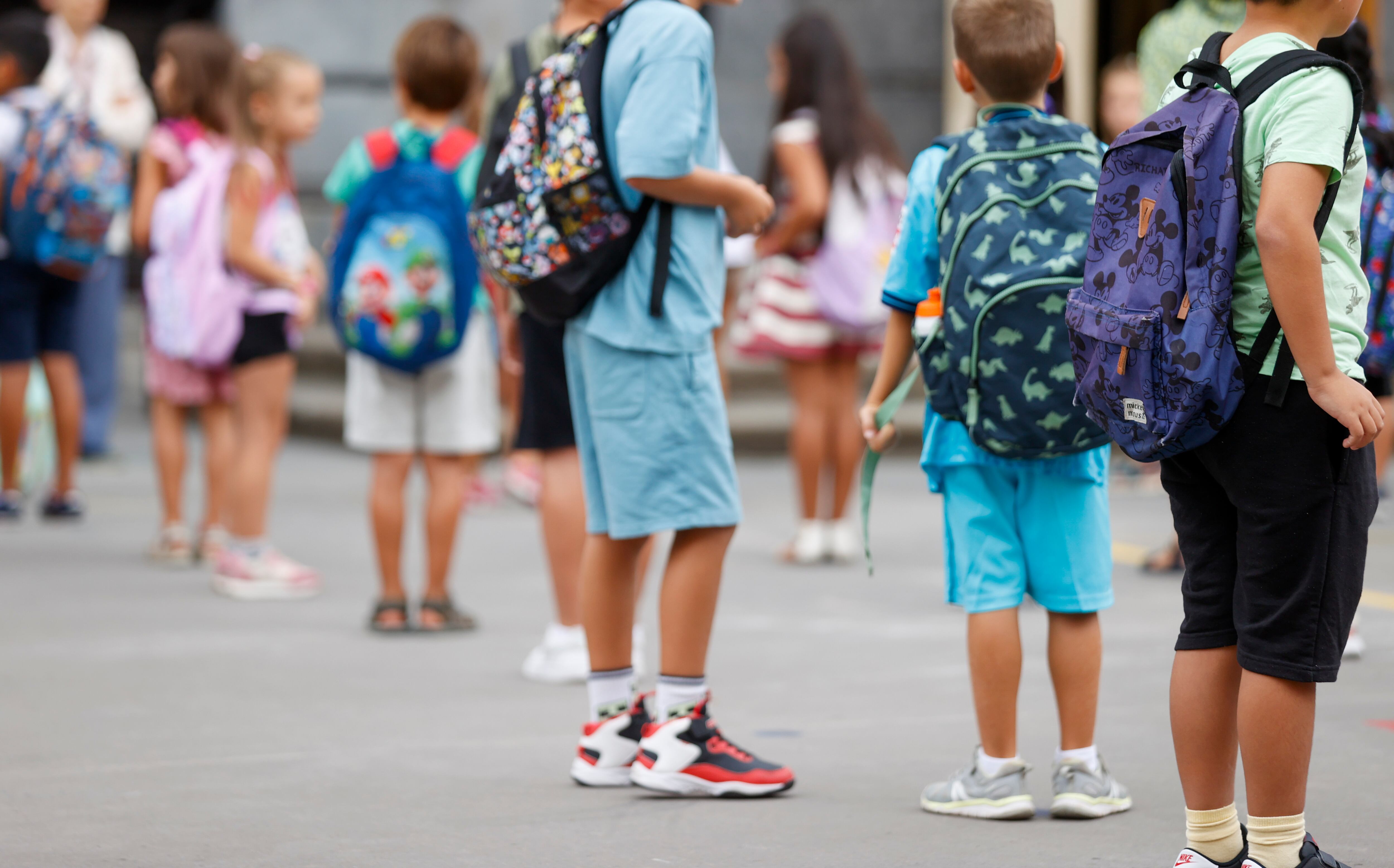 Varios niños frente a la entrada del colegio. (Luis Tejido/EFE)
