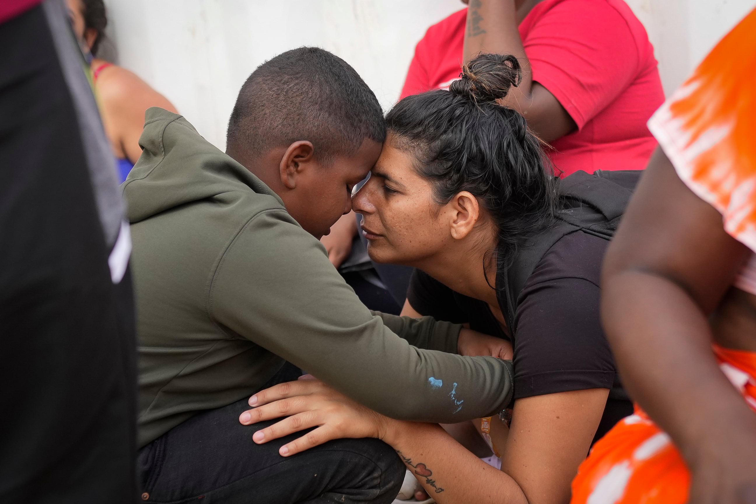La migrante venezolana Nelsy Zavala, a la derecha, abraza a un chico migrante venezolano Yeikel Mojica, a quien conoció mientras cruzaba el Tapón del Darién