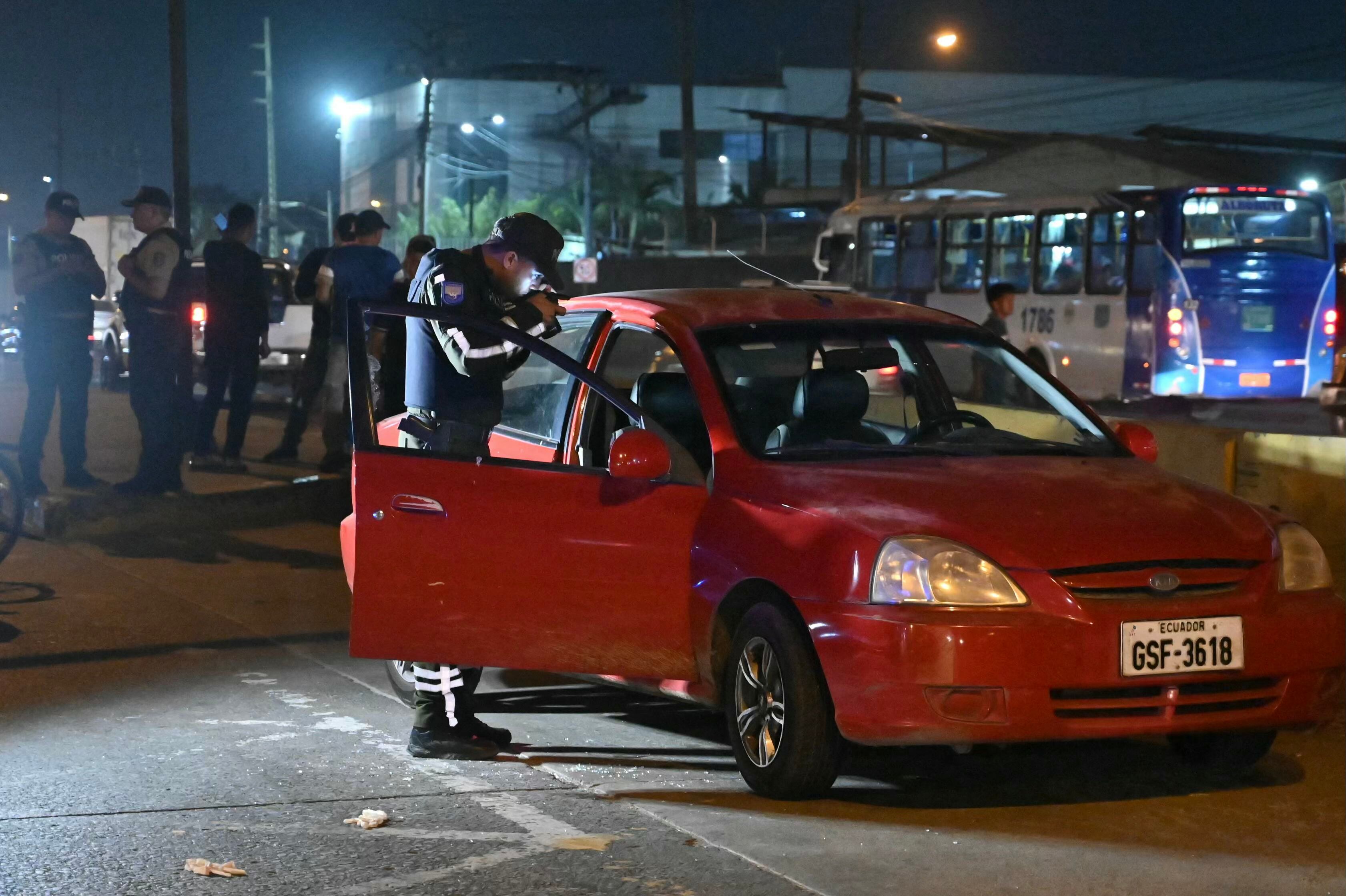 A police officer inspects the car of the director in charge of the Centro de Privaci�n de Libertad Masculina N�1 del Guayas, Mar�a Daniela Icaza, after being attacked in Guayaquil, Ecuador, on 12 September 2024. The director of a prison in Guayaquil, Ecuador's largest and the scene of some of the worst inmate killings, was murdered on Thursday, becoming the second prison official to be killed in ten days, the agency in charge of prisons (SNAI) said. (Photo by MARCOS PIN / AFP)