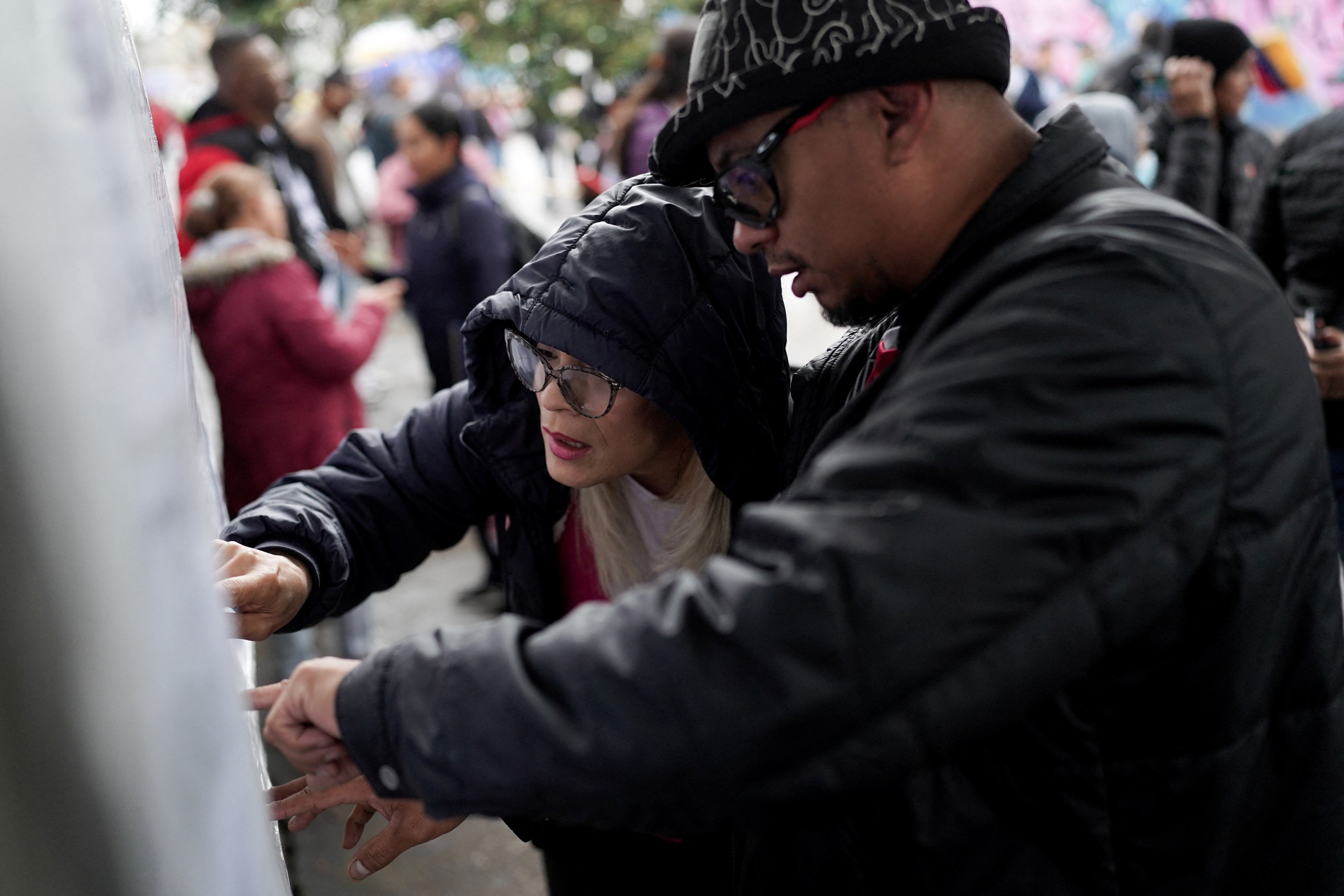 Venezolanos revisan sus puestos de votación en el Colegio Técnico Palermo, en Bogotá (REUTERS/Nathalia Angarita)