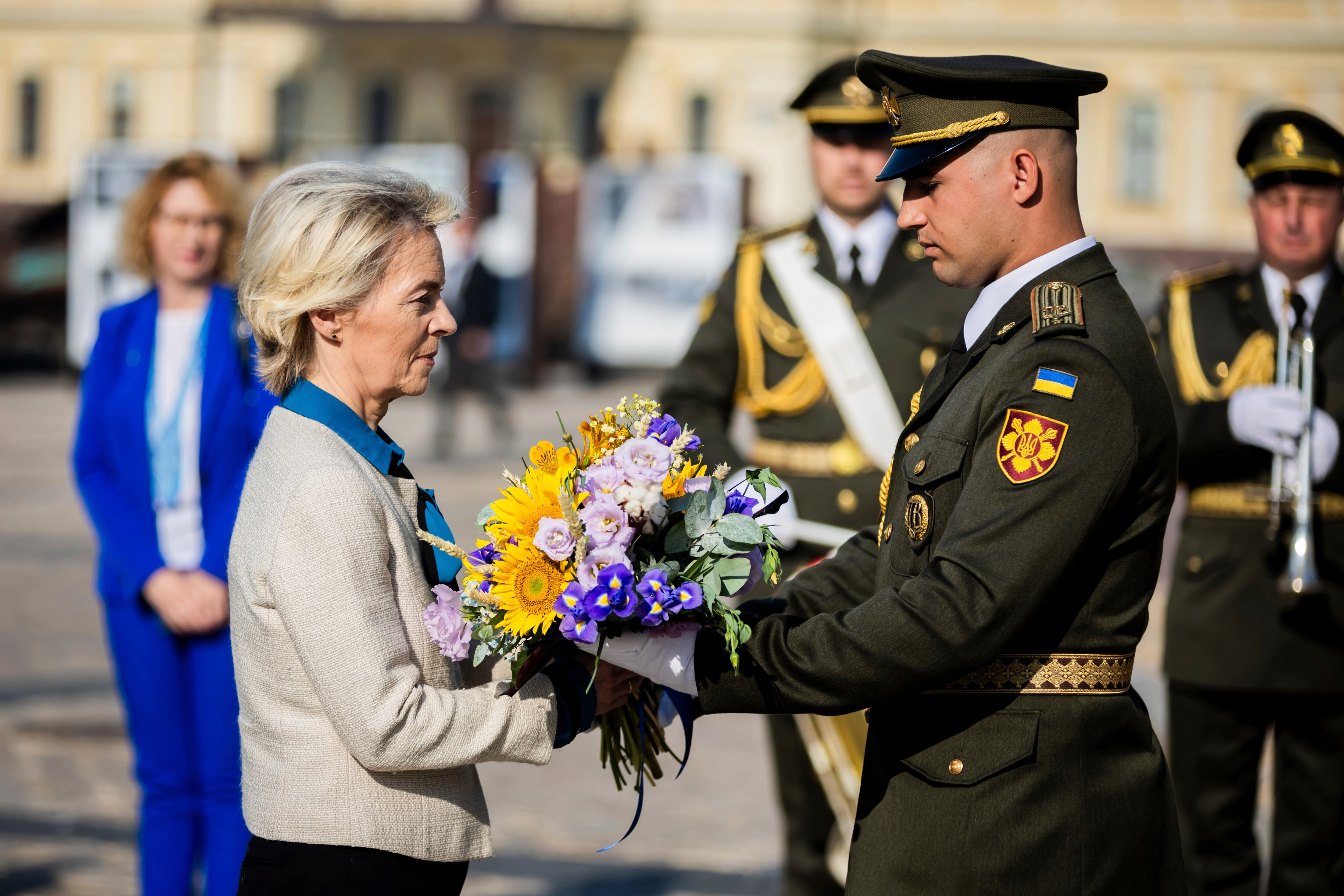 La presidenta de la Comisión Europea, Ursula Von der Leyen, recibe un ramo de rosas que será colocado frente a un muro en honor a los soldados ucranianos que han muerto en la guerra con Rusia, en Kiev, Ucrania (Christoph Soeder/Pool vía AP)