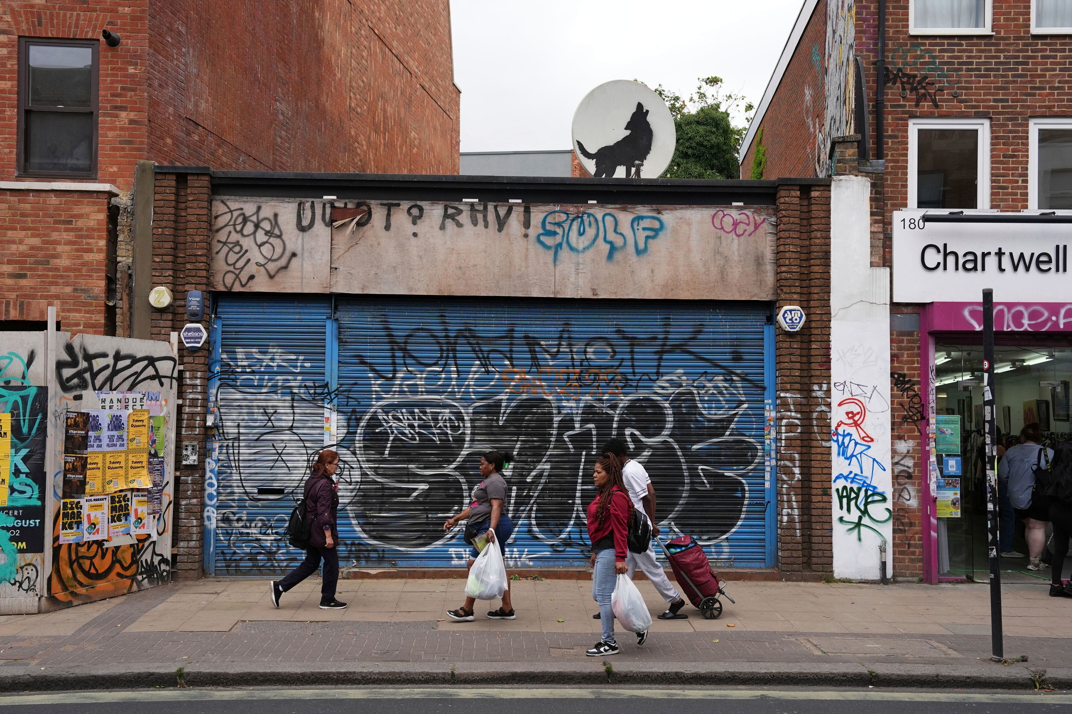 Un lobo aullando creada por Banksy sobre una antena parabólica  (Jordan Pettitt/PA via AP)