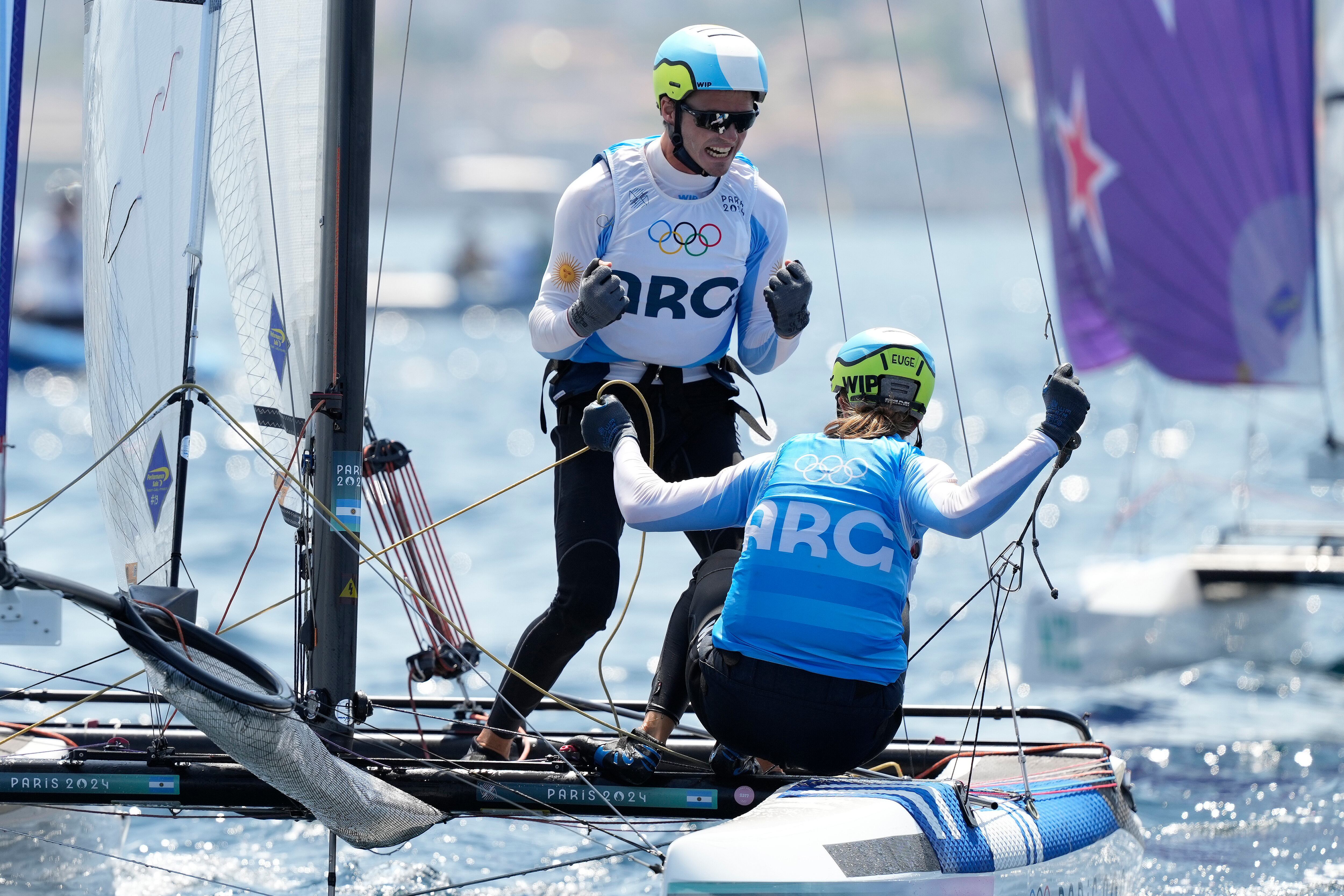 Los argentinos Eugenia Bosco y Mateo Majdalani celebran su medalla de bronce en la regata Nacra 17 mixta de los Juegos Olímpicos de París, el jueves 8 de agosto de 2024, en Marsella, Francia. (AP Foto/Daniel Cole)