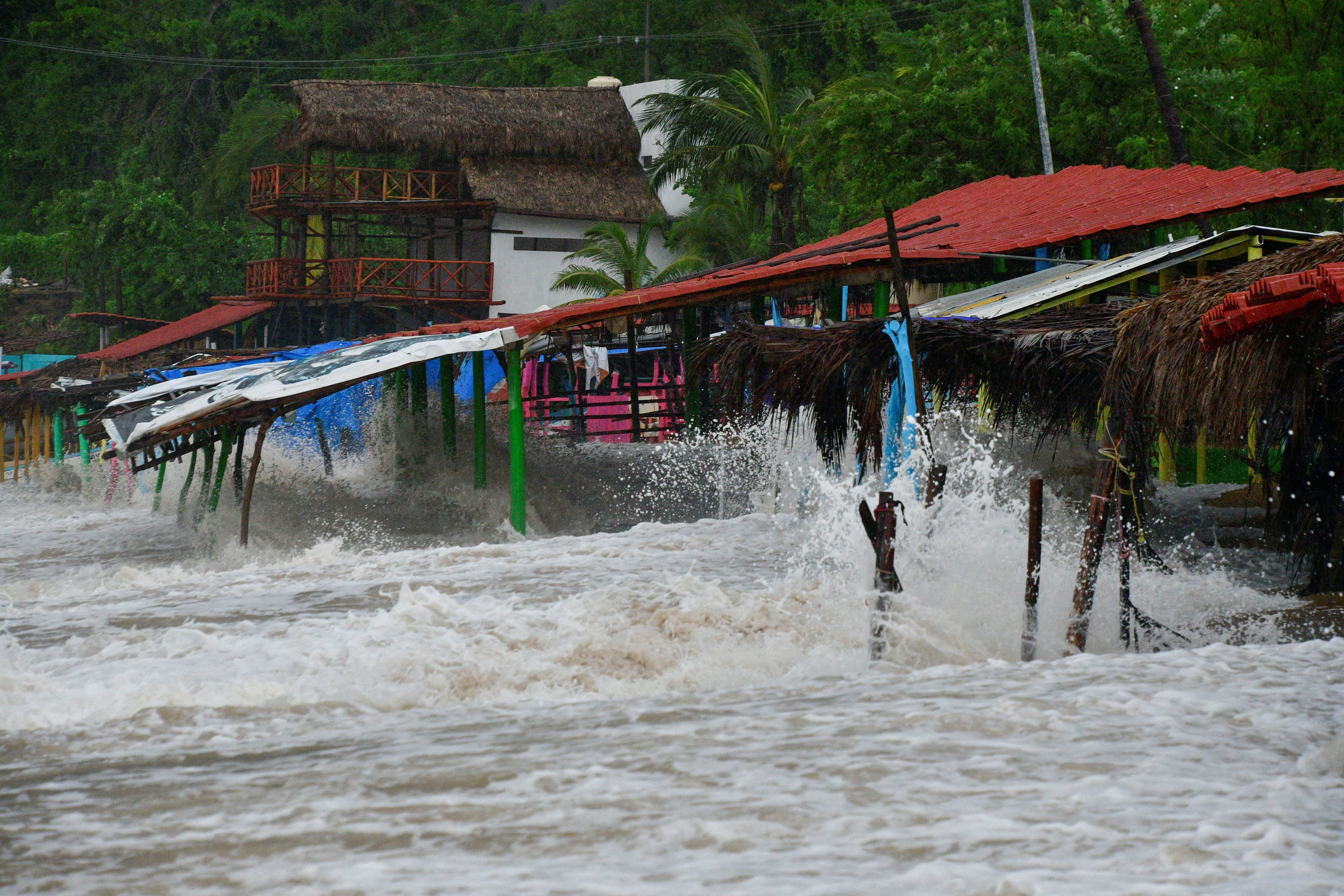 Waves break into restaurants on the beach as Tropical Storm John is on track to become a hurricane again, hurtling back towards communities across the Pacific coast, in Acapulco, Mexico September 25, 2024. REUTERS/Javier Verdin     TPX IMAGES OF THE DAY