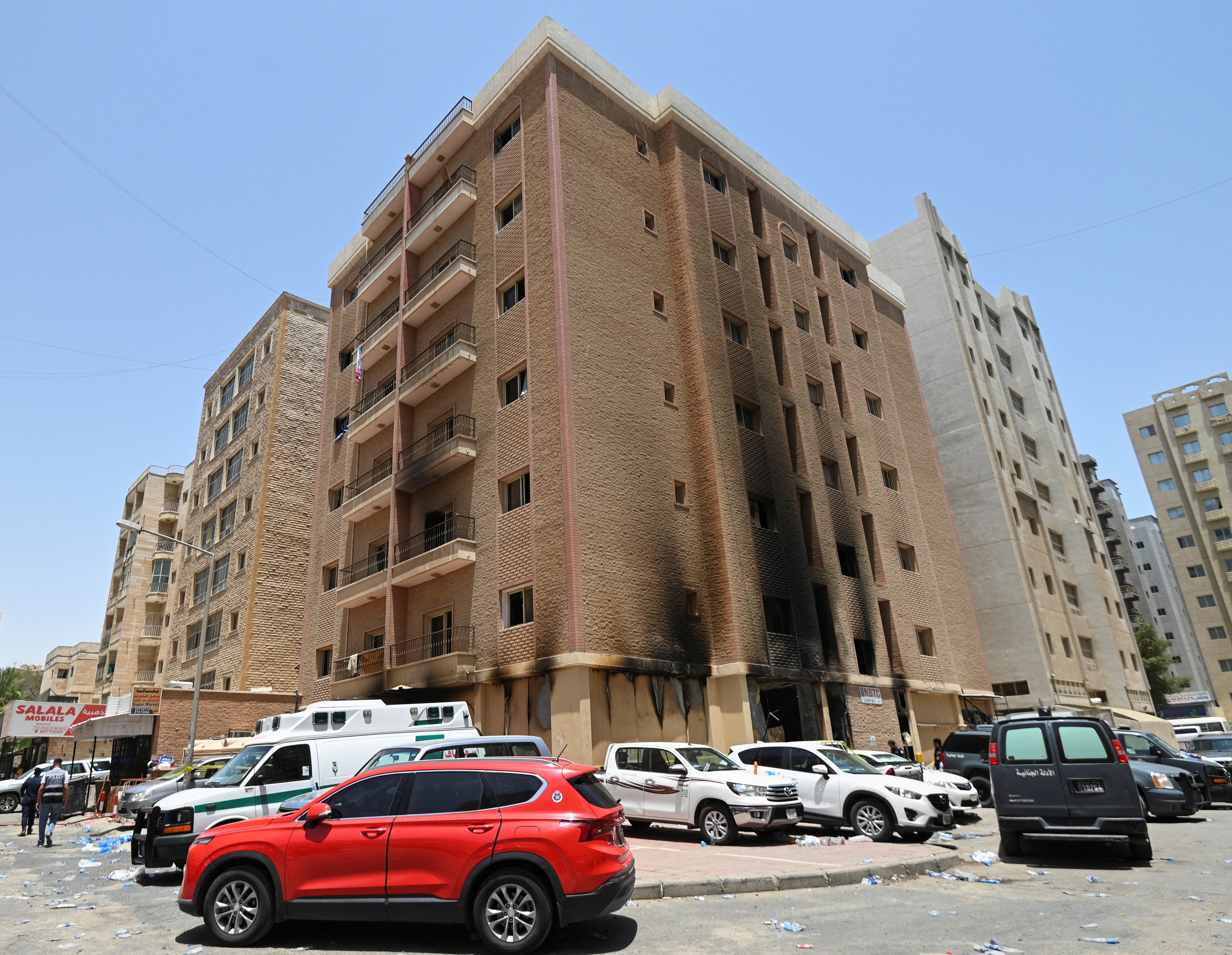 Vehículos aparcados junto a un edificio dañado tras un incendio mortal, en Mangaf, al sur de Kuwait (REUTERS)