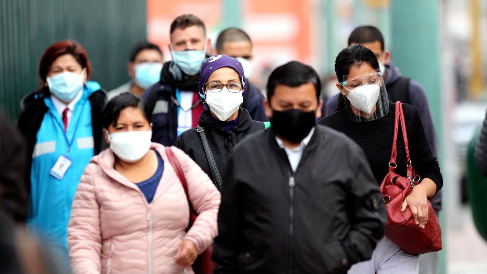 Un grupo de personas transitan por una avenida principal de Lima con mascarilla, para evitar la propagación de los contagios por coronavirus en el Perú.