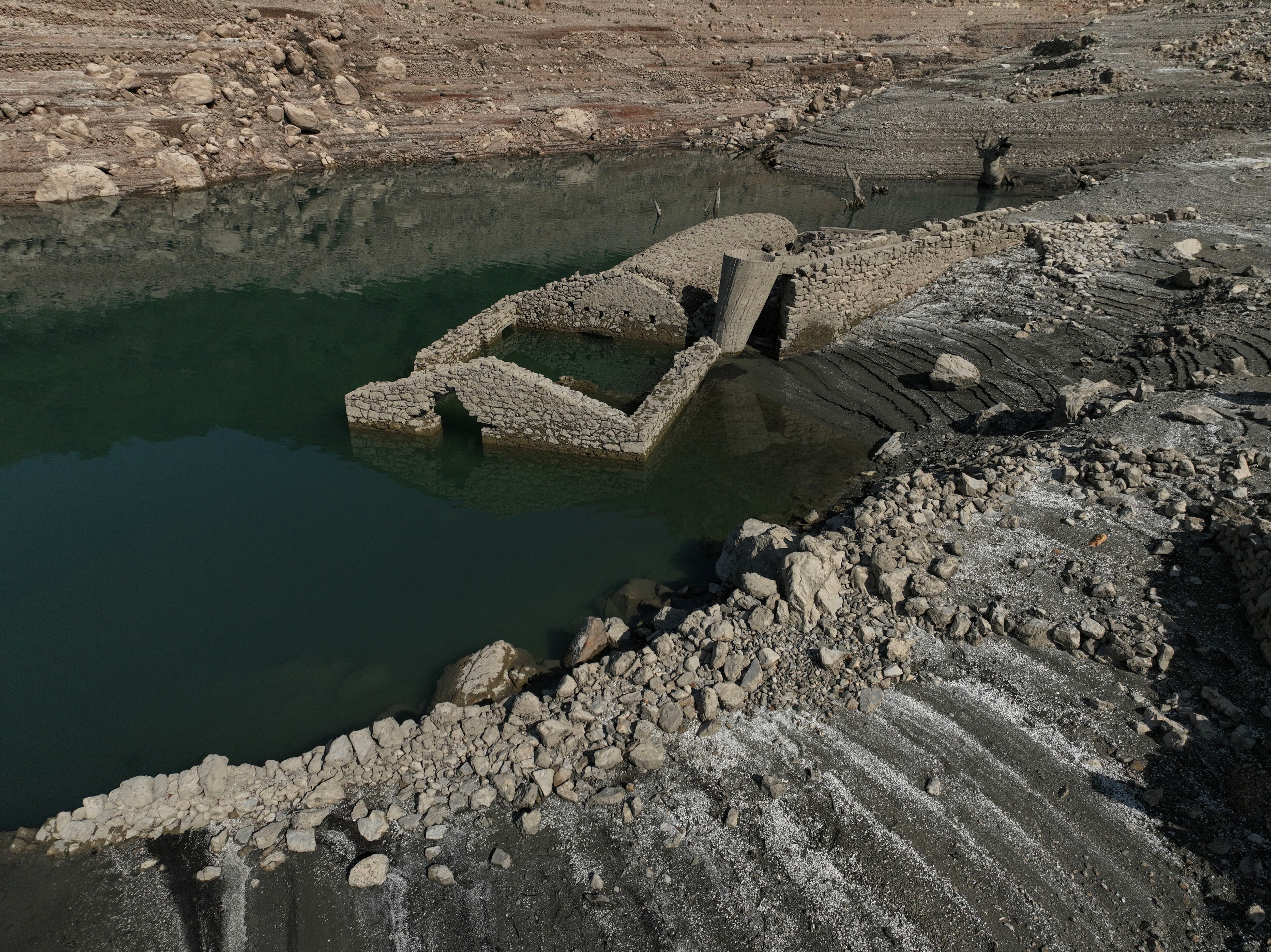 Ex habitantes de Kallio observan con asombro los edificios emergiendo del embalse (REUTERS/Stelios Misinas)