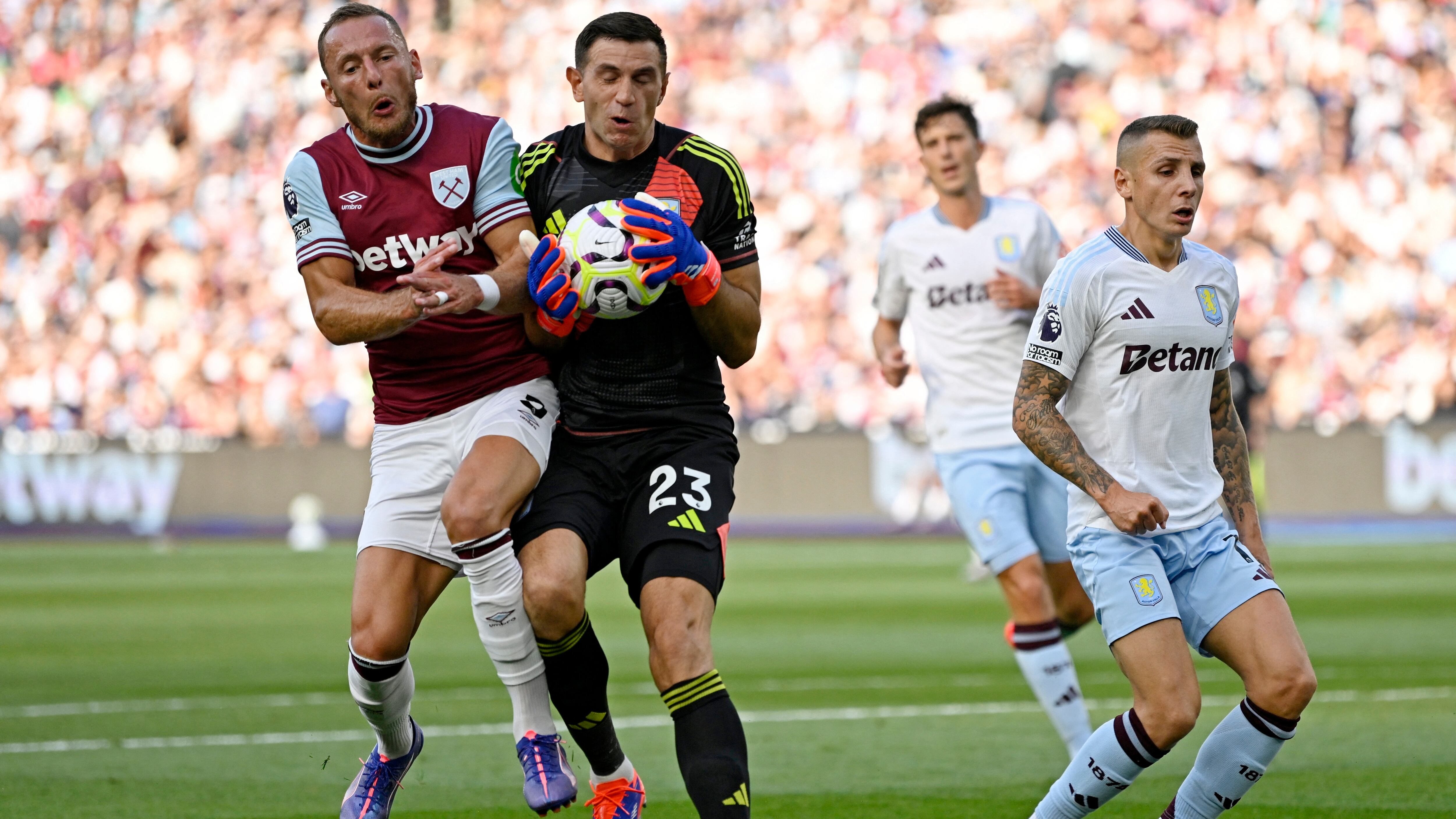 Soccer Football - Premier League - West Ham United v Aston Villa - London Stadium, London, Britain - August 17, 2024 West Ham United's Vladimir Coufal in action with Aston Villa's Emiliano Martinez REUTERS/Tony O Brien EDITORIAL USE ONLY. NO USE WITH UNAUTHORIZED AUDIO, VIDEO, DATA, FIXTURE LISTS, CLUB/LEAGUE LOGOS OR 'LIVE' SERVICES. ONLINE IN-MATCH USE LIMITED TO 120 IMAGES, NO VIDEO EMULATION. NO USE IN BETTING, GAMES OR SINGLE CLUB/LEAGUE/PLAYER PUBLICATIONS. PLEASE CONTACT YOUR ACCOUNT REPRESENTATIVE FOR FURTHER DETAILS..