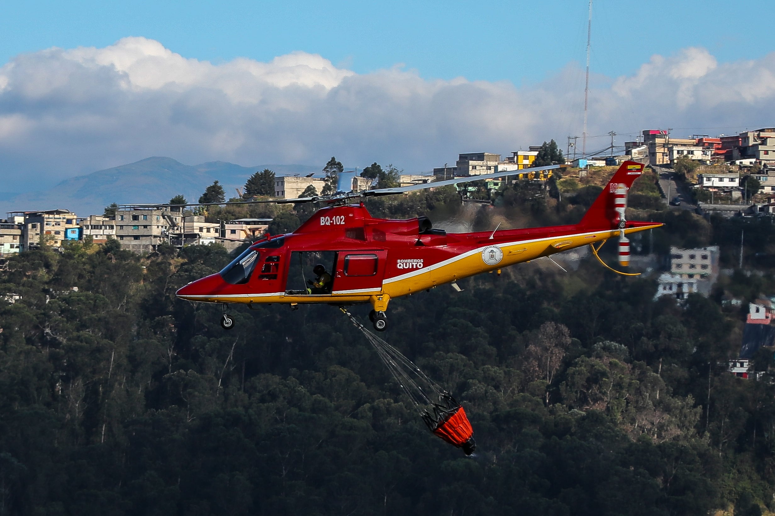 Fotografía de un helicóptero de bomberos lanzando agua para extinguir un incendio el 12 de septiembre de 2024 en las laderas del cerro El Panecillo, ubicado en el centro Histórico de Quito (Ecuador). EFE/José Jácome
