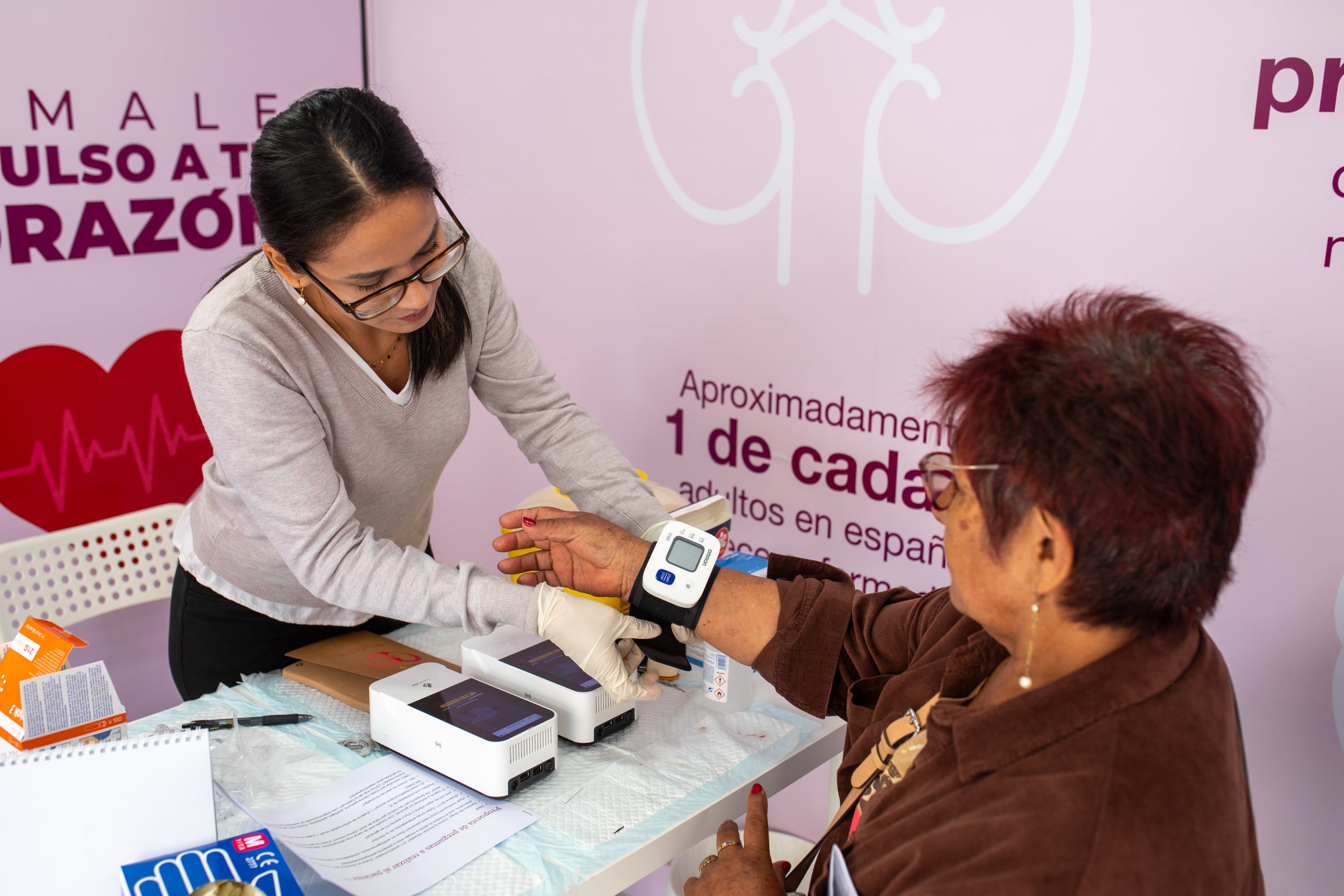 Una enfermera toma el pulso de una mujer en la unidad móvil de AstraZeneca en Callao (Helena Margarit Cortadellas / Infobae España)