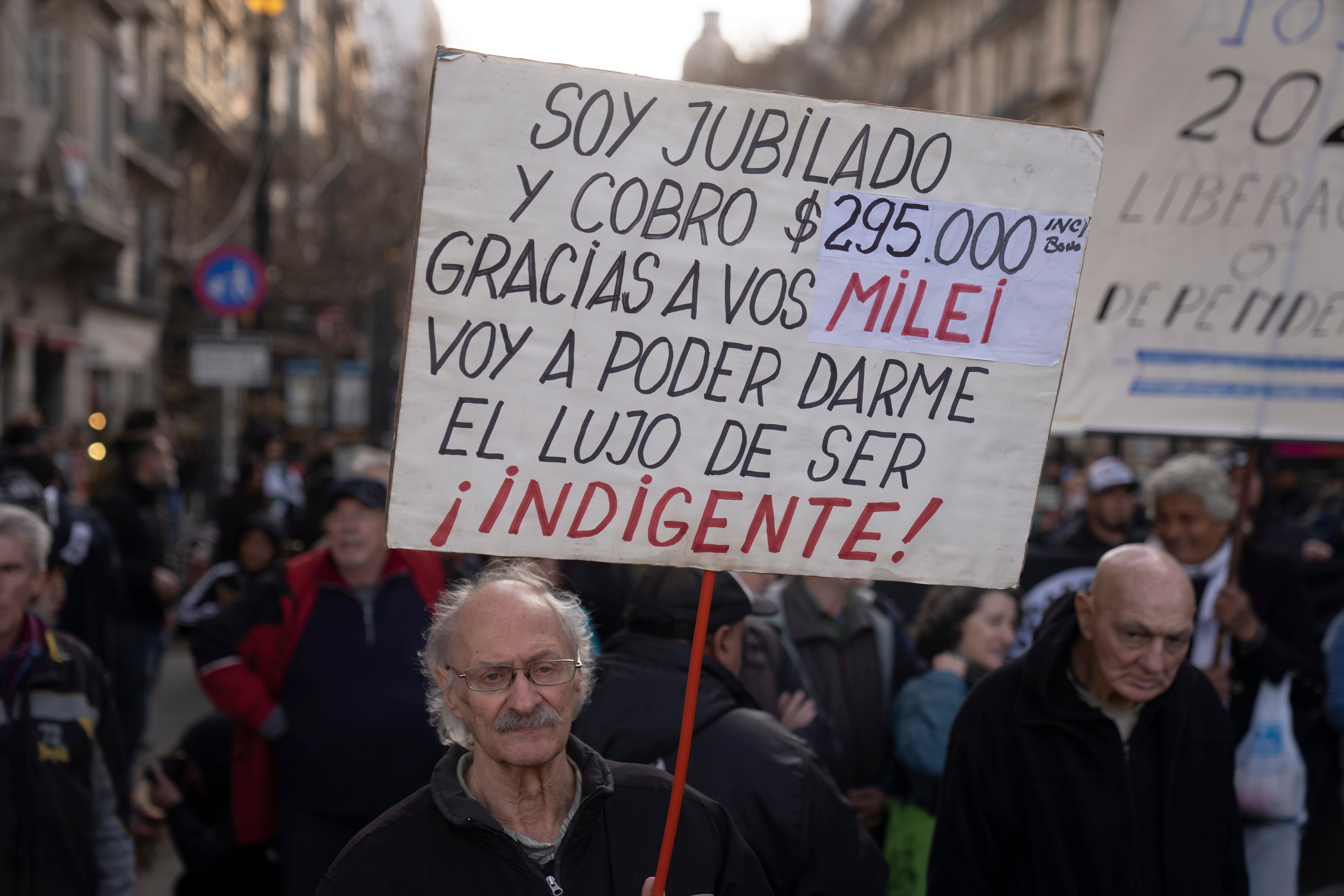 Un jubilado sostiene un cartel durante una protesta contra el veto presidencial al proyecto de ley aprobado por el Congreso para aumentar las jubilaciones (AP Foto/Víctor R. Caivano)