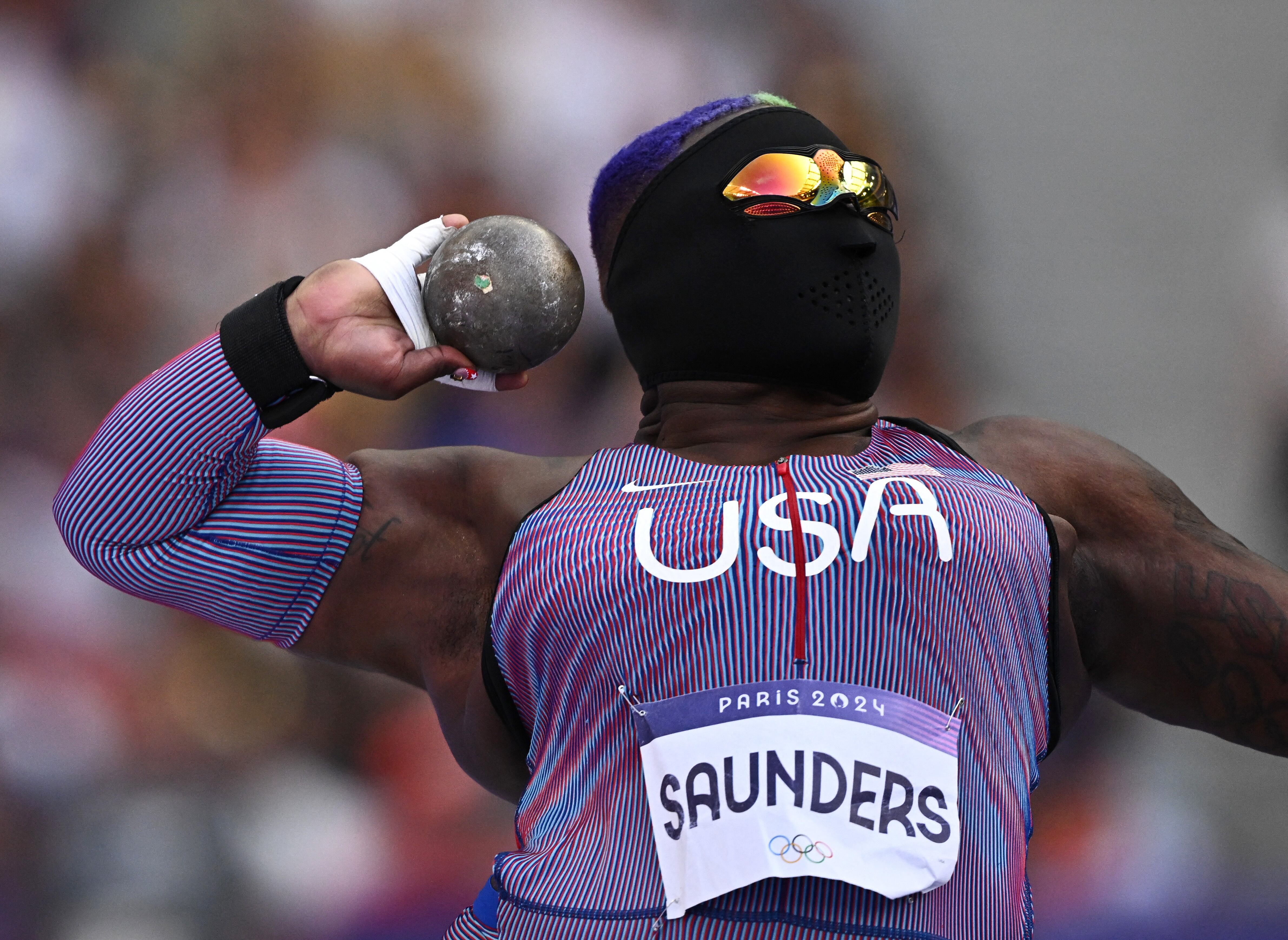 Máscara negra y gafas de sol de colores, el atuendo de Saunders para lanzar balas en los Juegos Olímpicos (REUTERS/Dylan Martinez)