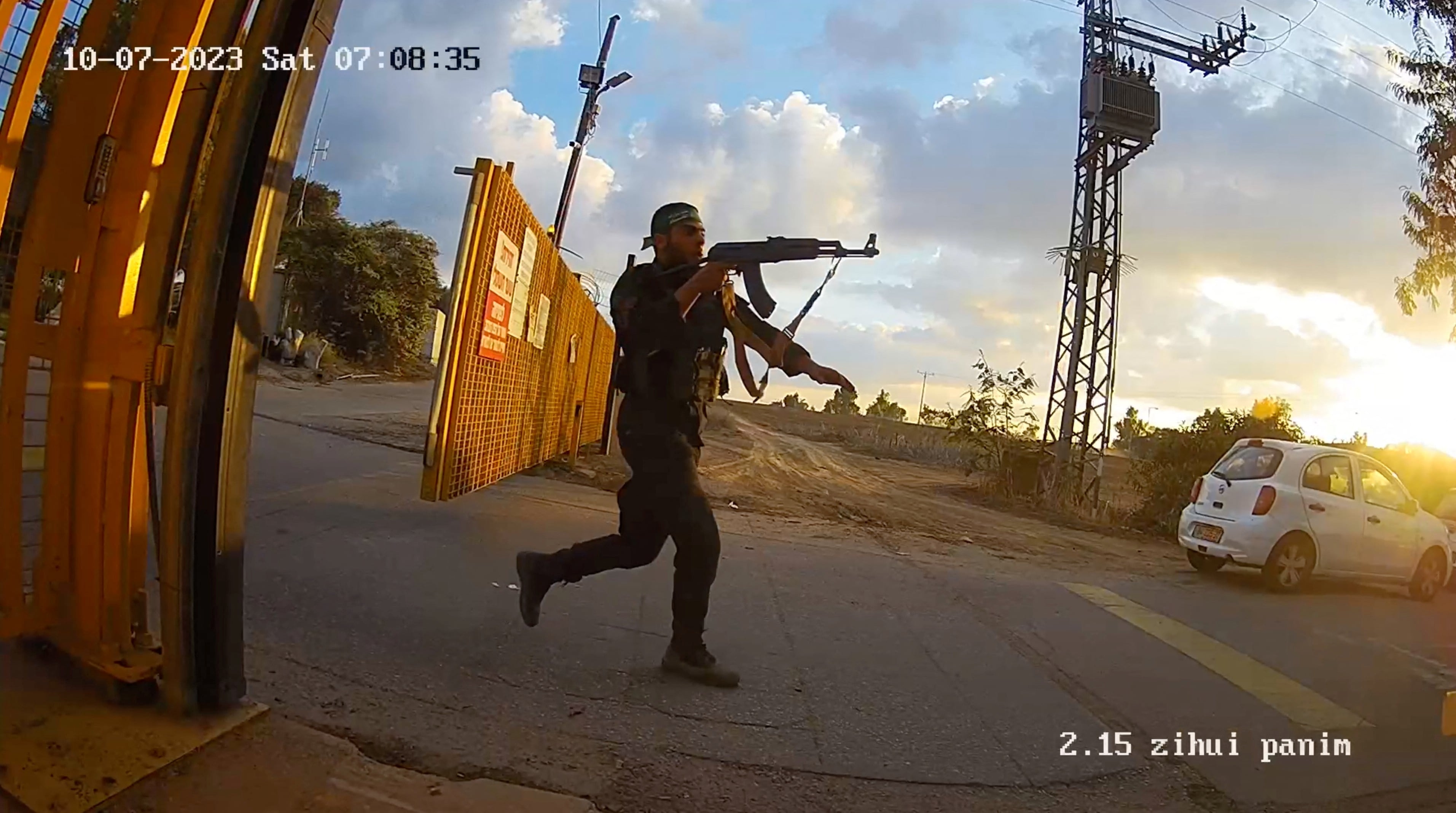 Un hombre armado corre apuntando con su arma durante el ataque del 7 de octubre en esta captura de pantalla de la filmación de una cámara de vigilancia en el kibutz Alumim, sur de Israel
