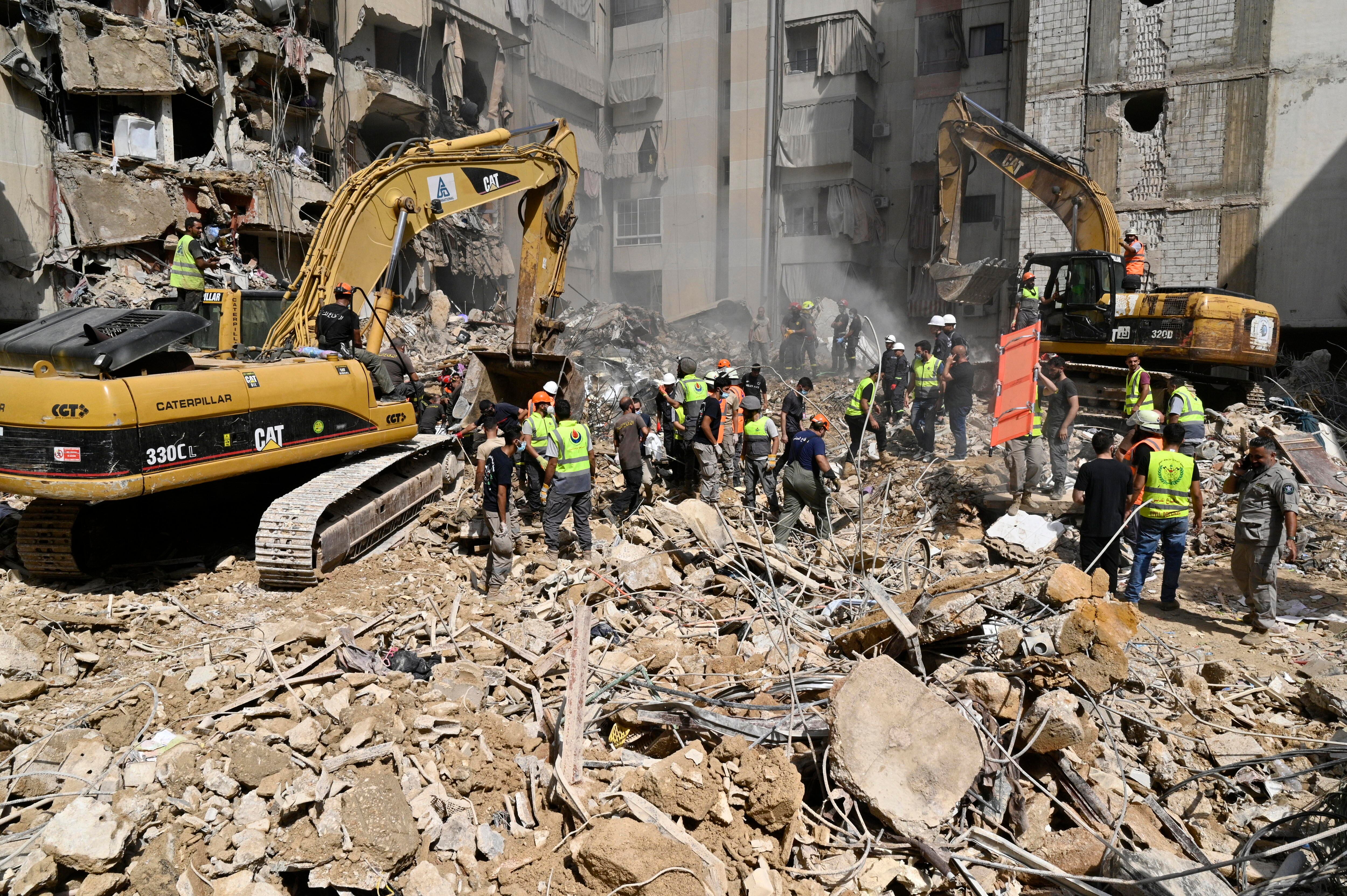 Los trabajadores de emergencia utilizan excavadoras para limpiar los escombros en un lugar que fue blanco de un ataque israelí en un suburbio del sur de Beirut, Líbano (EFE/Wael Hamzeh)