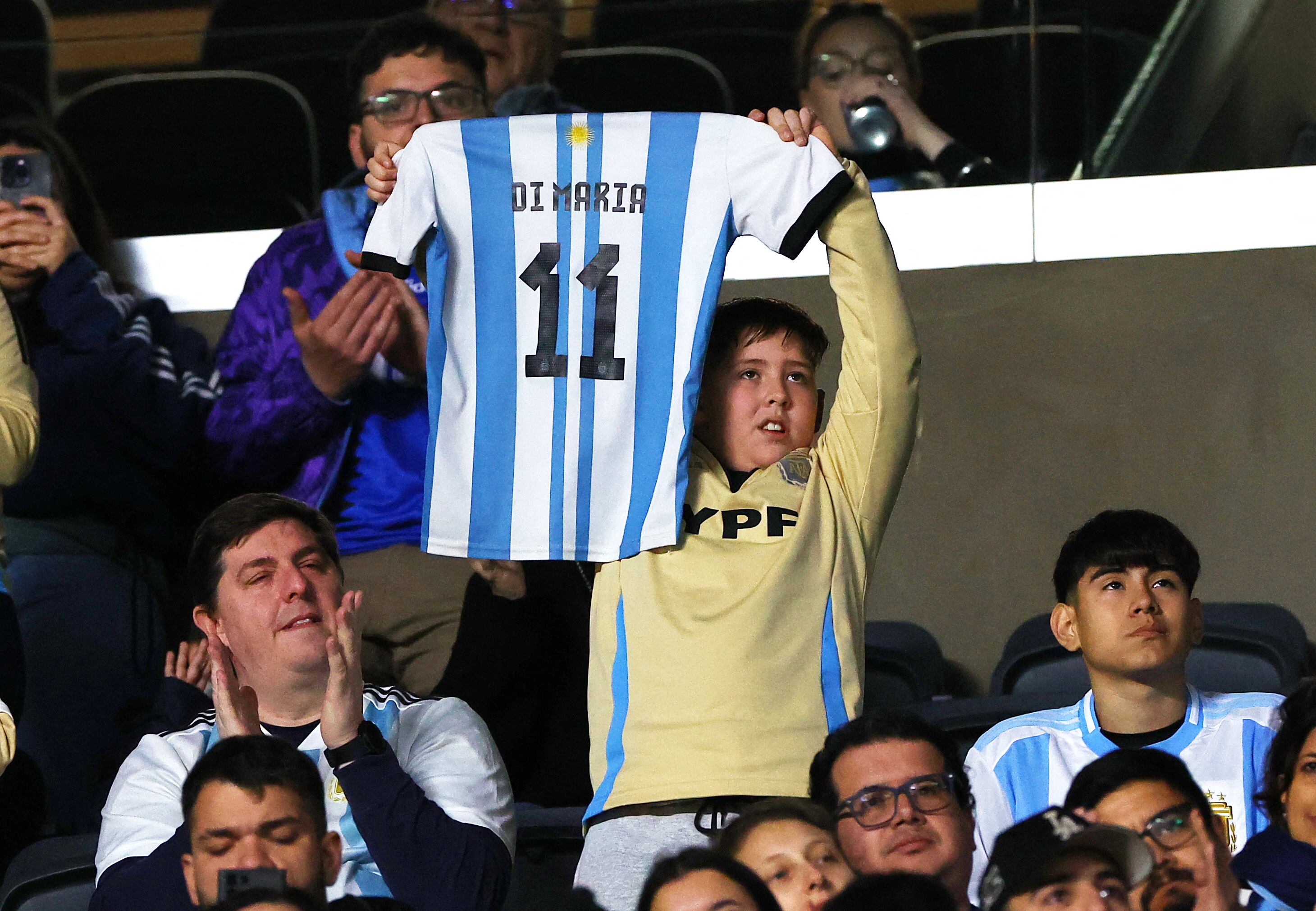 El niño muestra la camiseta con el número 11 que identificó a Di María en los últimos años en el seleccionado