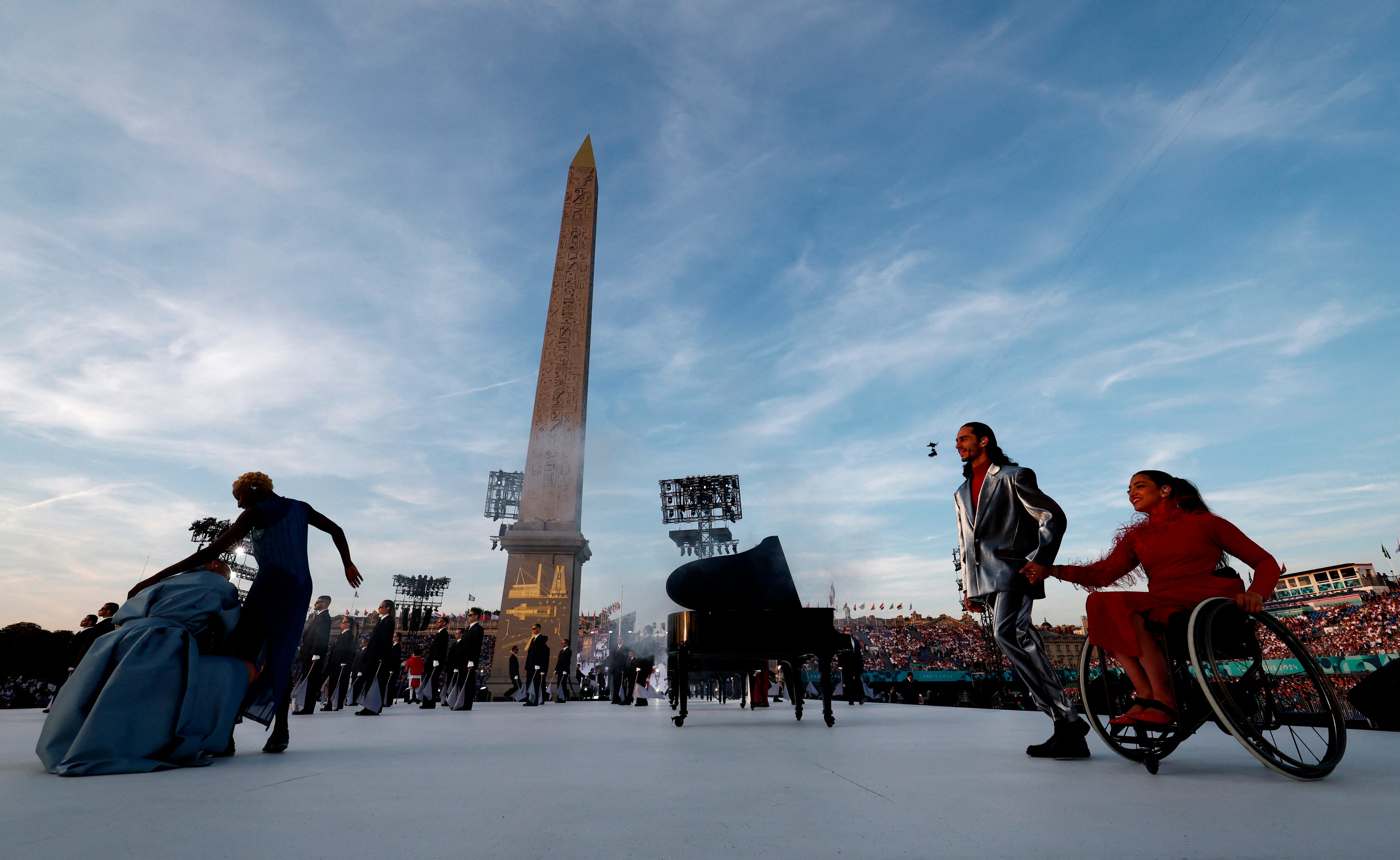 Artistas durante la ceremonia de apertura mientras se ve el Obelisco de Luxor en la Plaza de la Concordia - crédito REUTERS/Gonzalo Fuentes